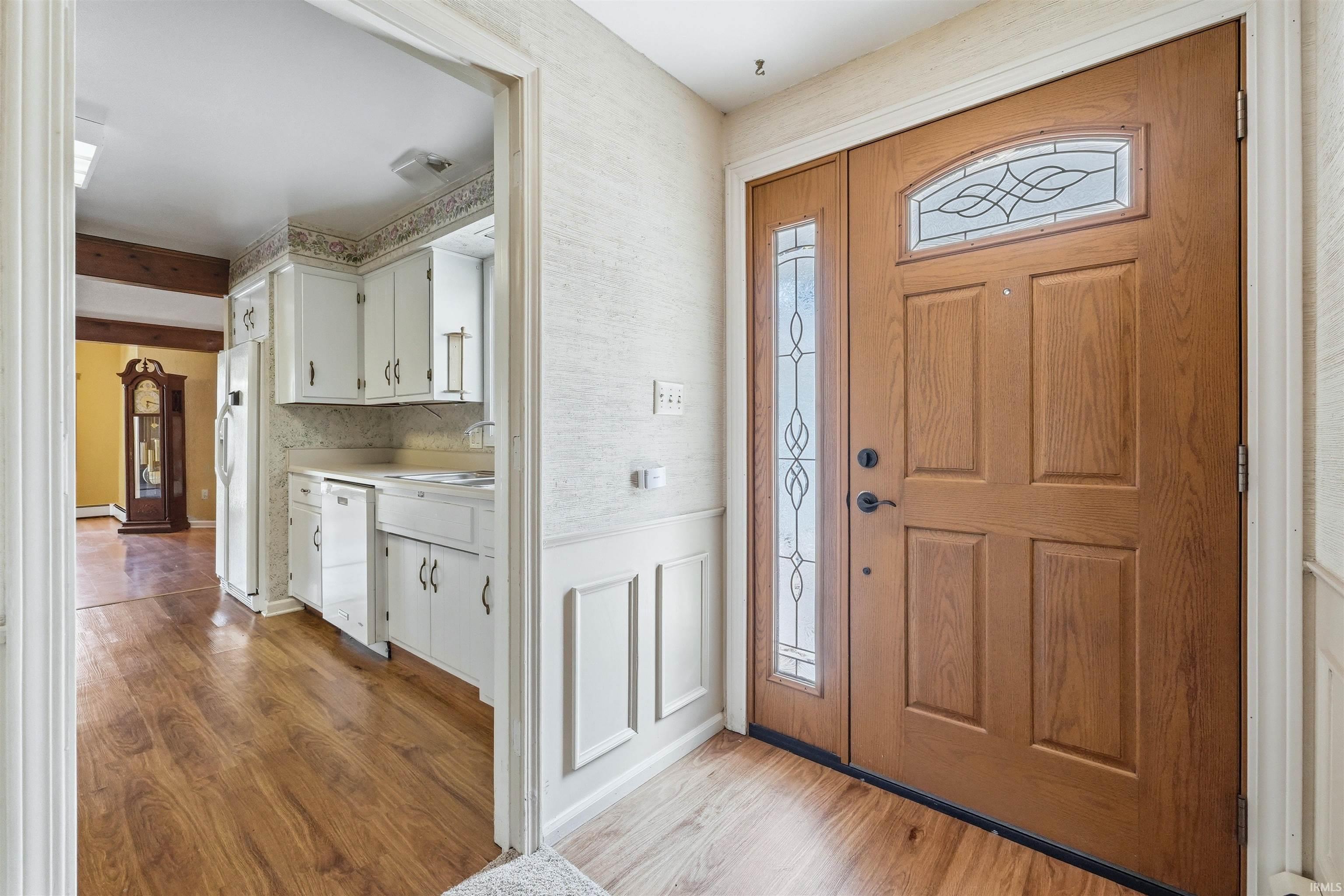 Entryway featuring a wood-finish door with decorative glass inserts and a matching sidelight