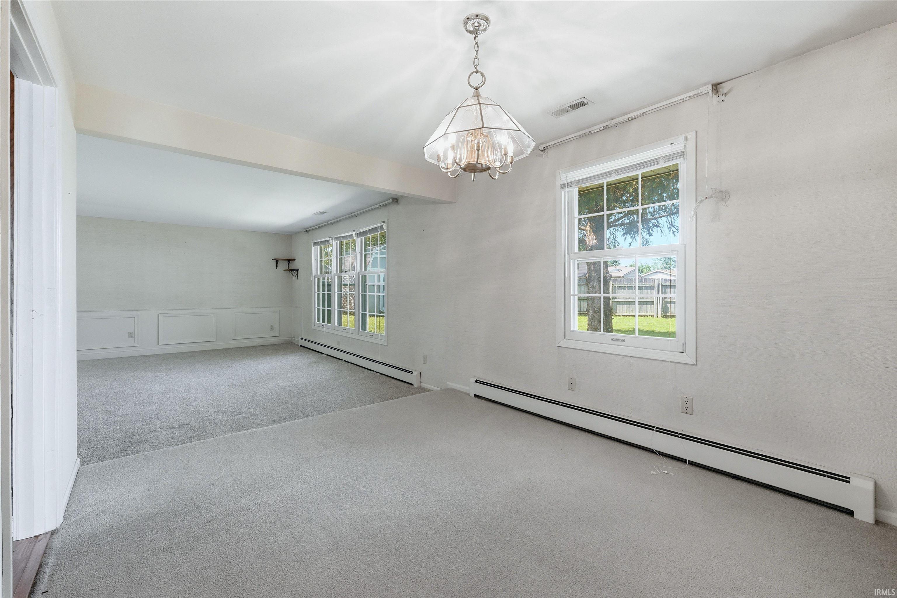 Open-concept living space with light gray wall-to-wall carpeting and neutral wall tones