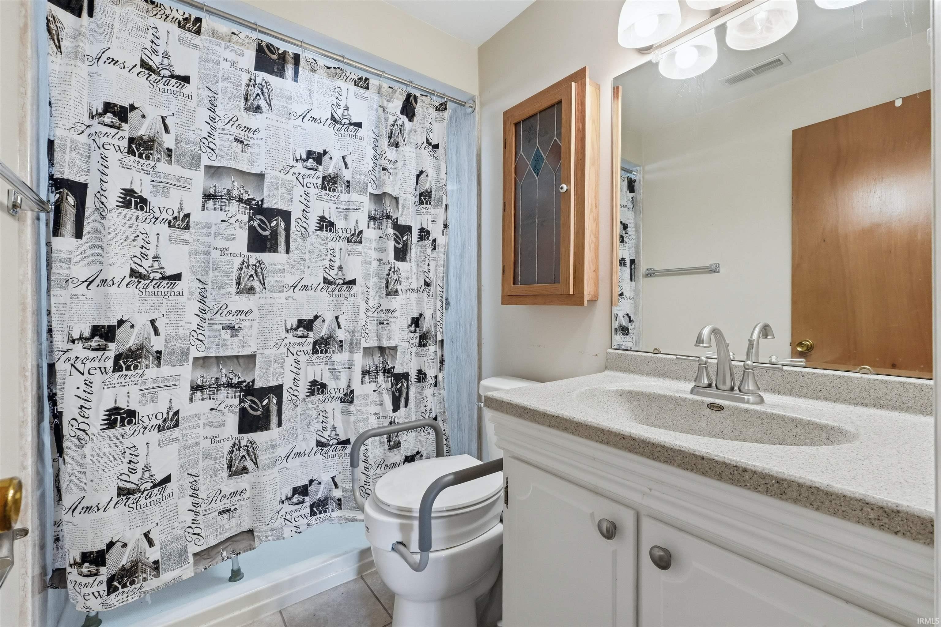 Bathroom vanity featuring a speckled countertop, integrated sink, and brushed nickel faucet