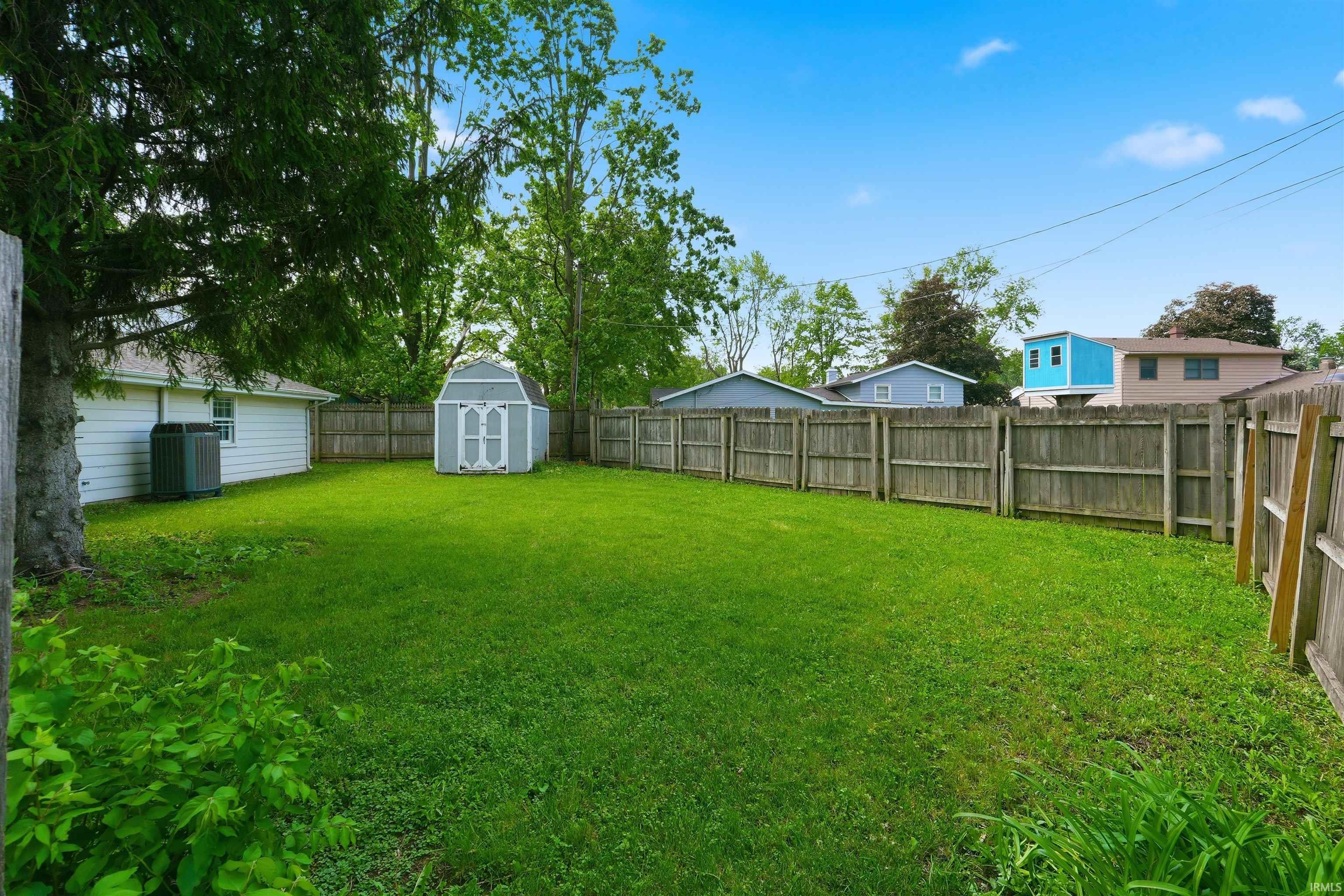 Expansive green lawn with a wood privacy fence