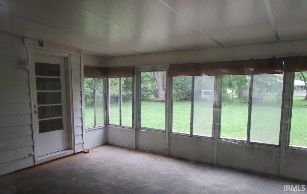 Screened-in porch featuring a full-light exterior door, multiple windows, and a wood-finish ceiling