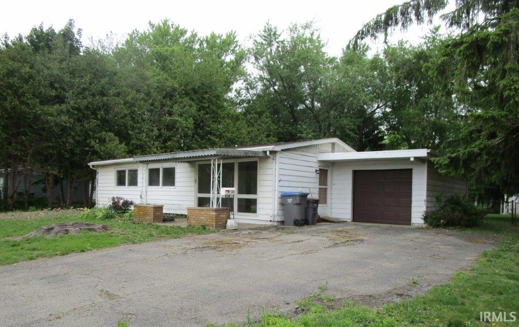 Single-story residence featuring white siding and a brown garage door