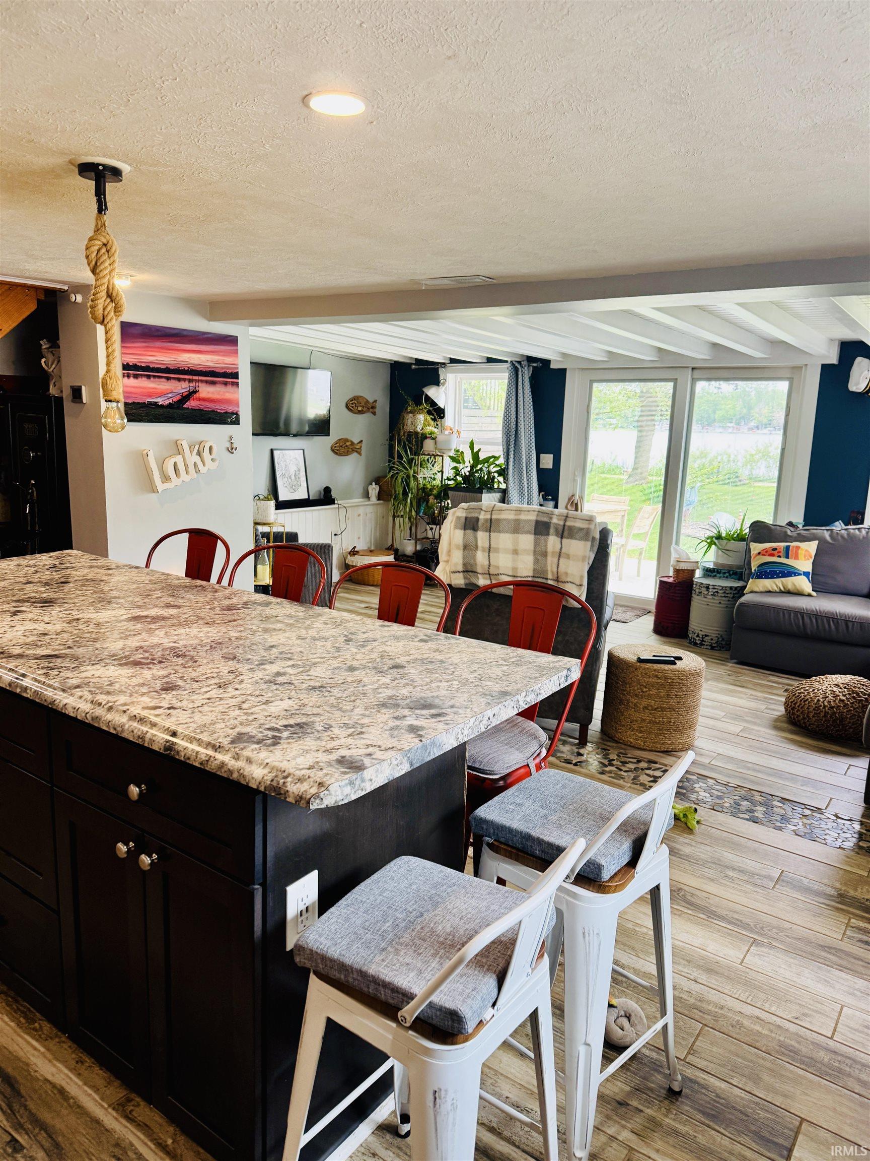 Kitchen island featuring a granite-finish countertop and dark wood cabinetry