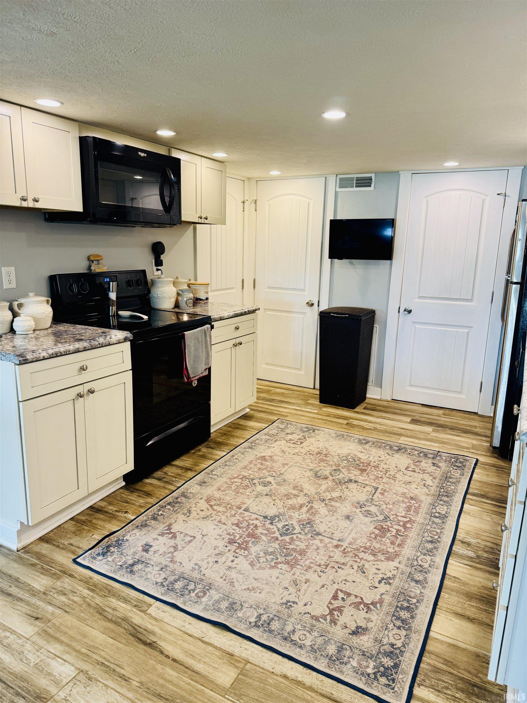 Kitchen featuring wood-finish flooring and recessed lighting