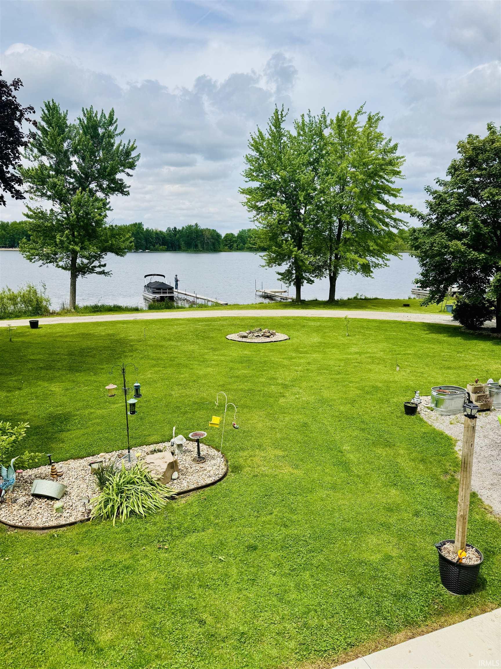 Expansive green lawn extending to the waterfront, featuring a private dock with boat access