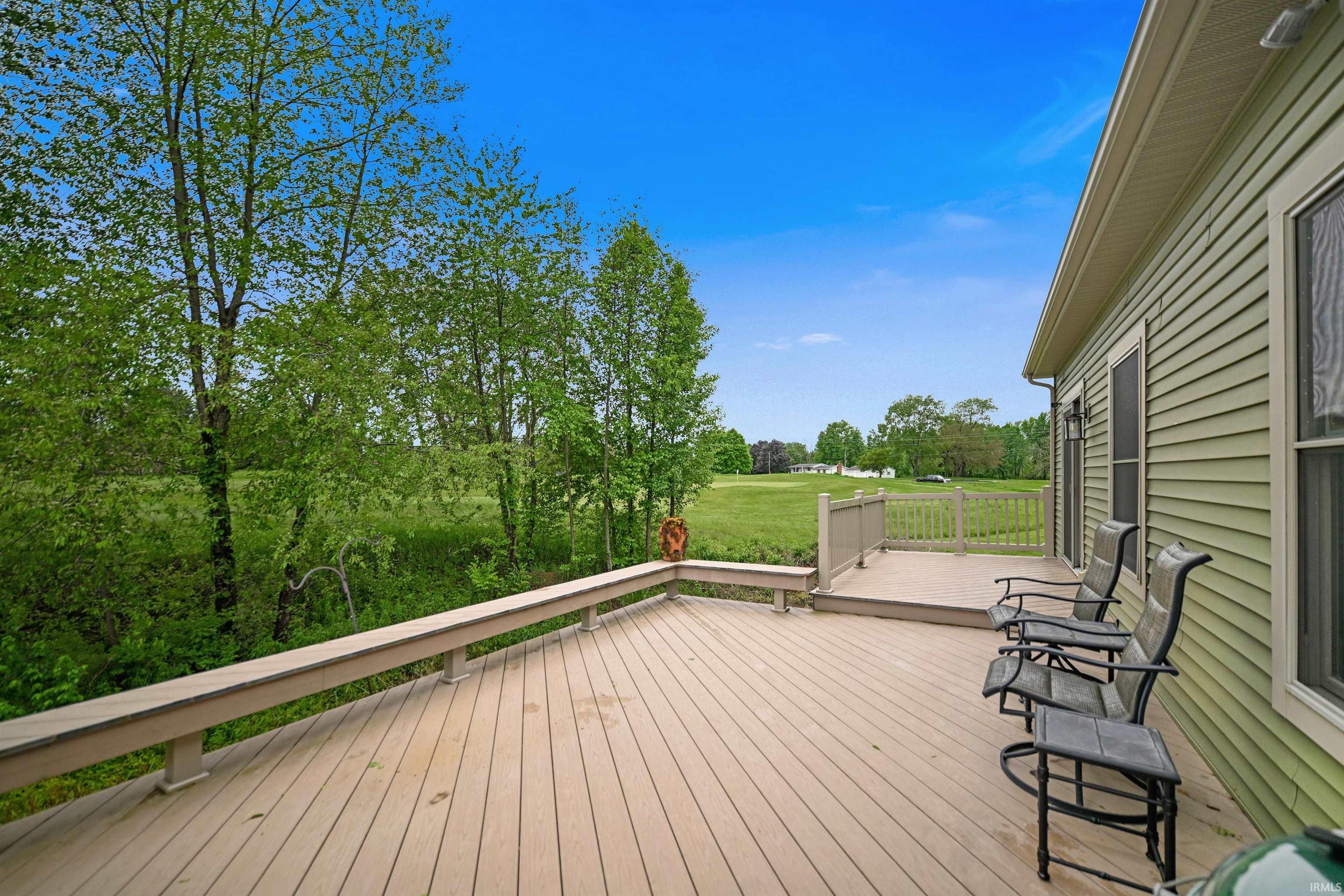 Expansive outdoor deck featuring wood-finish flooring, a built-in bench, and perimeter railings