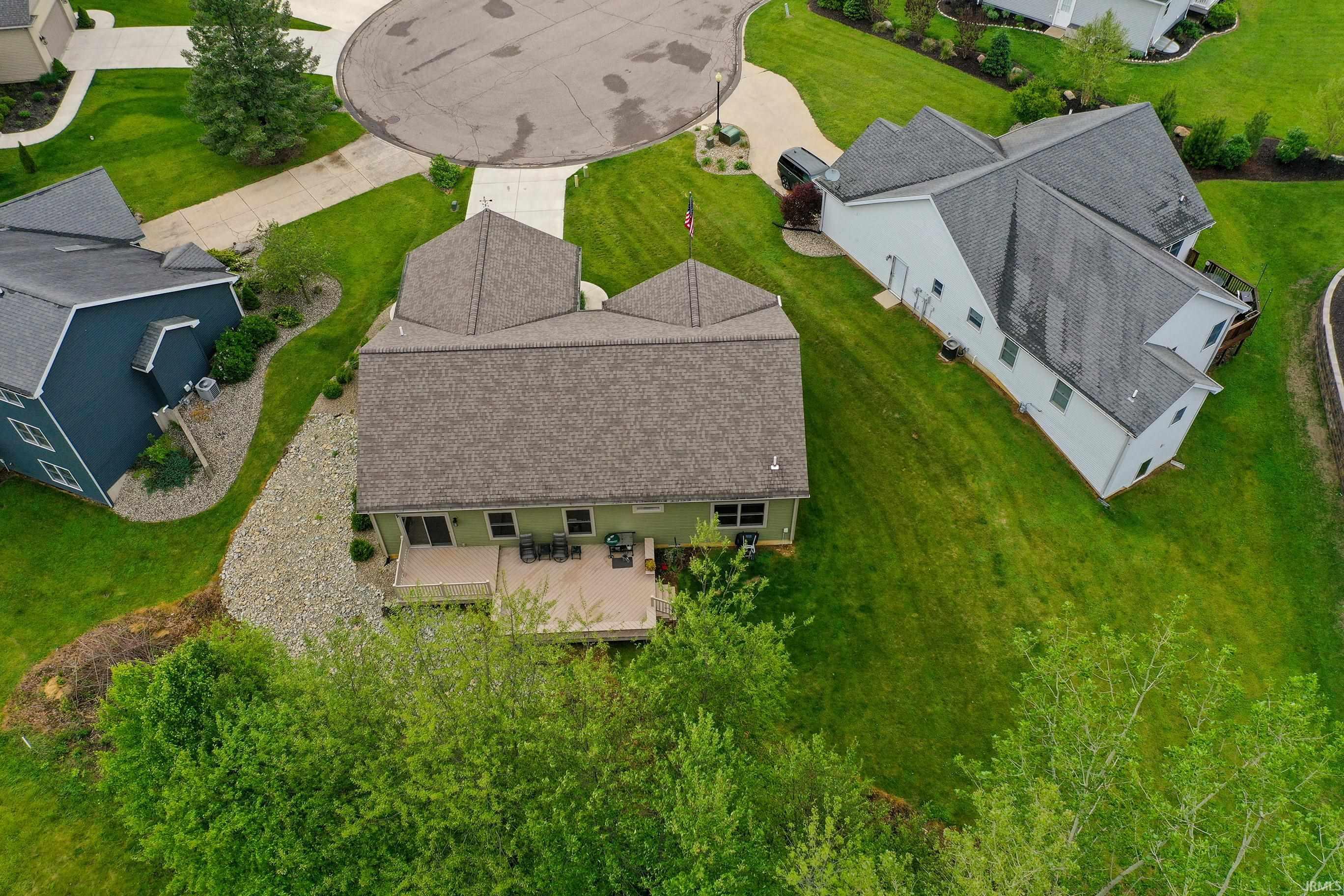 Property featuring a private rear deck, green siding, and a multi-pitch roof