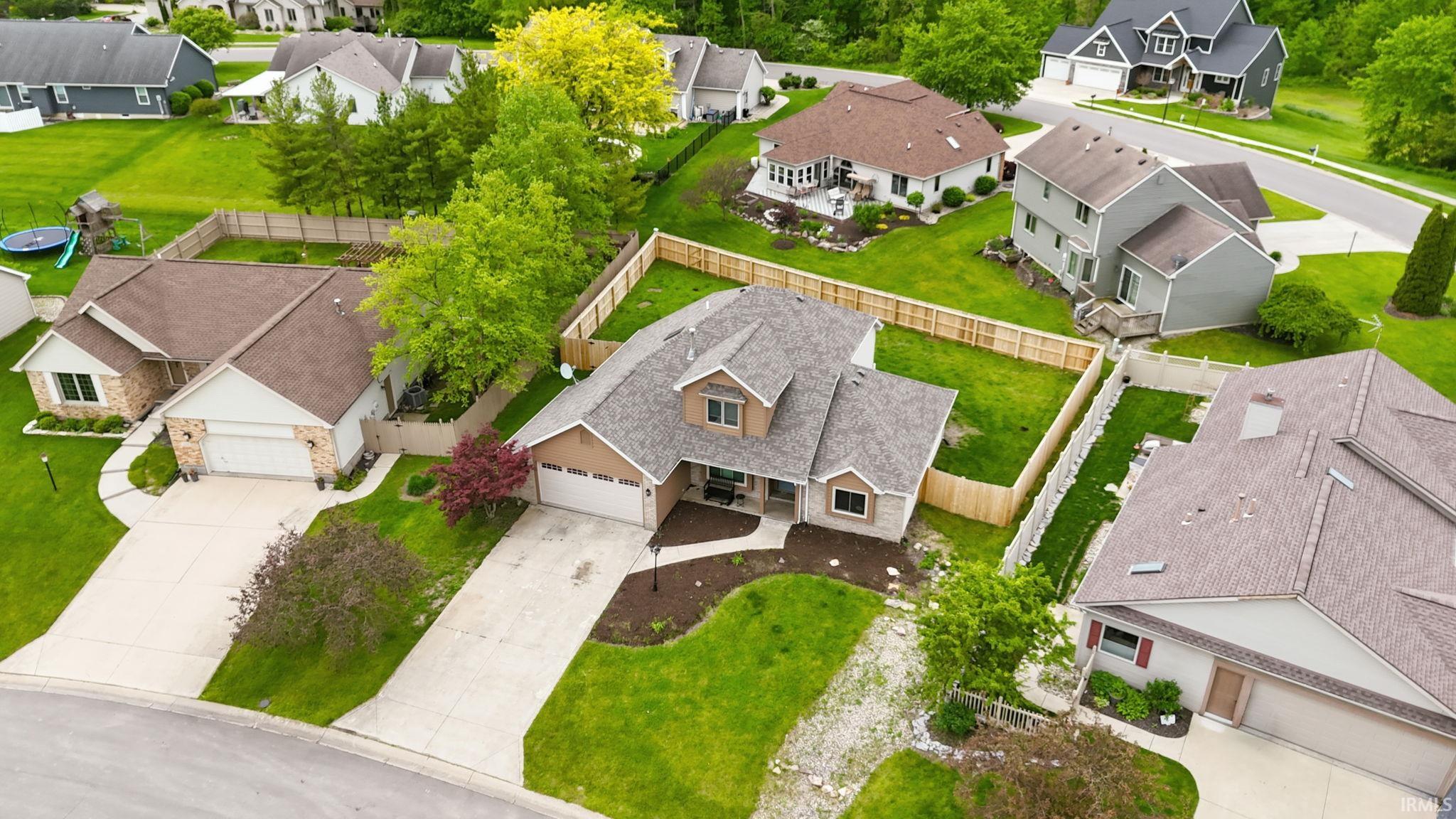 Contemporary style home featuring a multi-gabled roofline, stone and siding exterior, two-car attached garage, and a manicured front lawn with established landscaping
