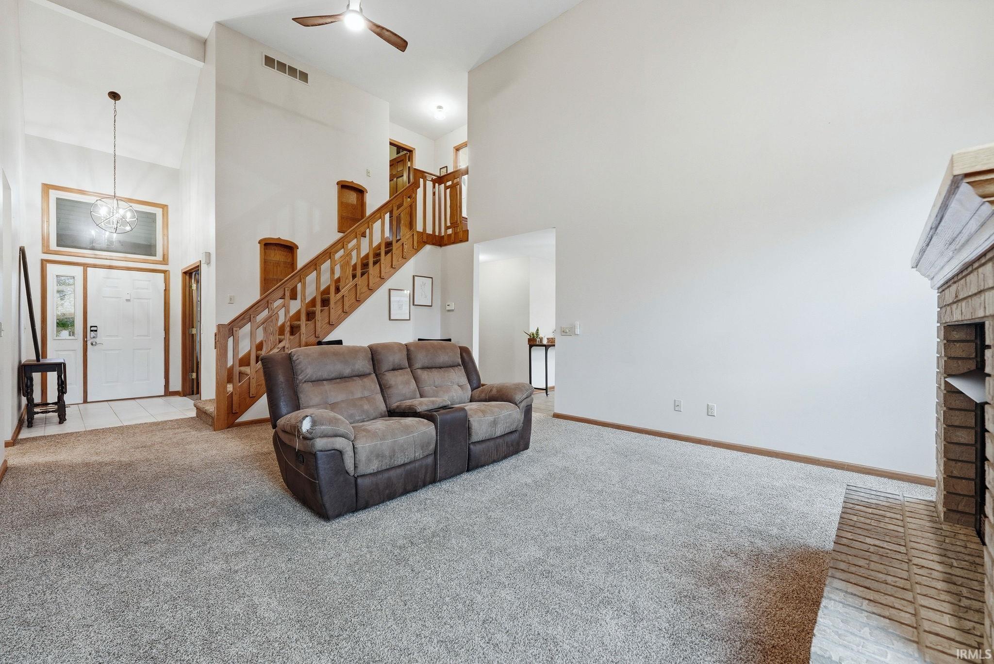 High ceilings and a prominent wood staircase define this bright living space