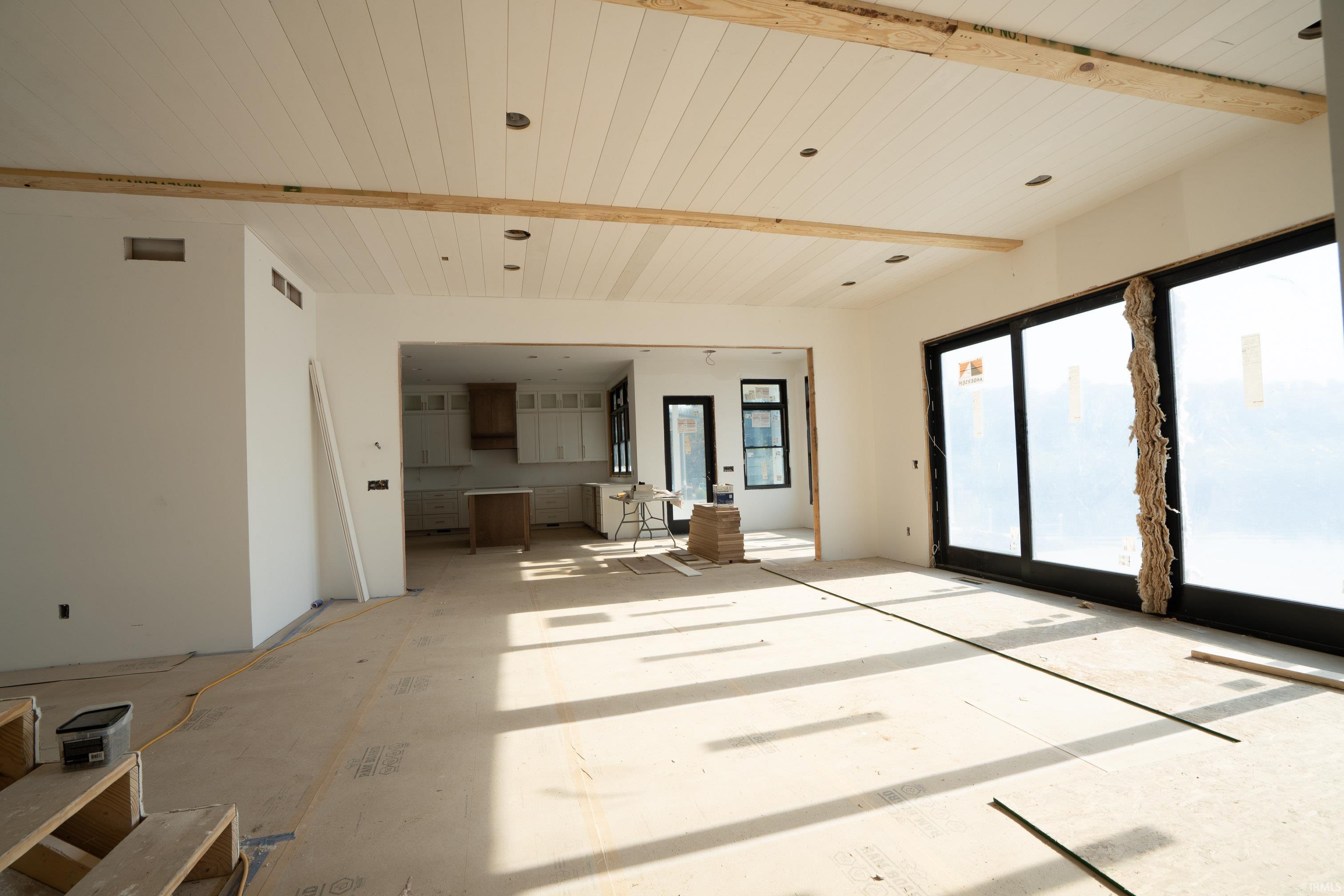 Spacious interior with exposed wood beams and white shiplap ceiling