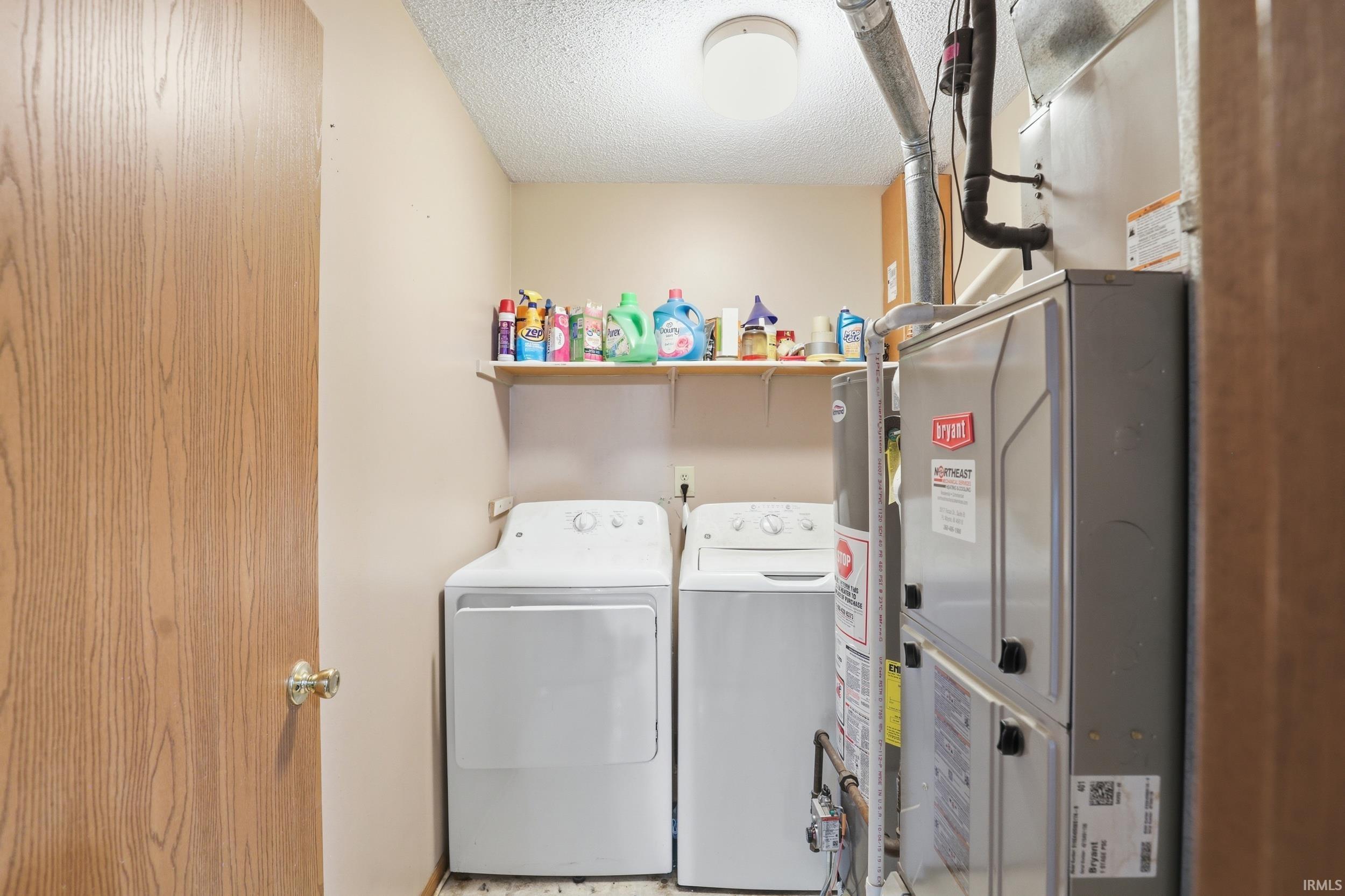 Dedicated laundry area featuring a washer and dryer, an overhead shelf for storage, and ceiling-mounted lighting