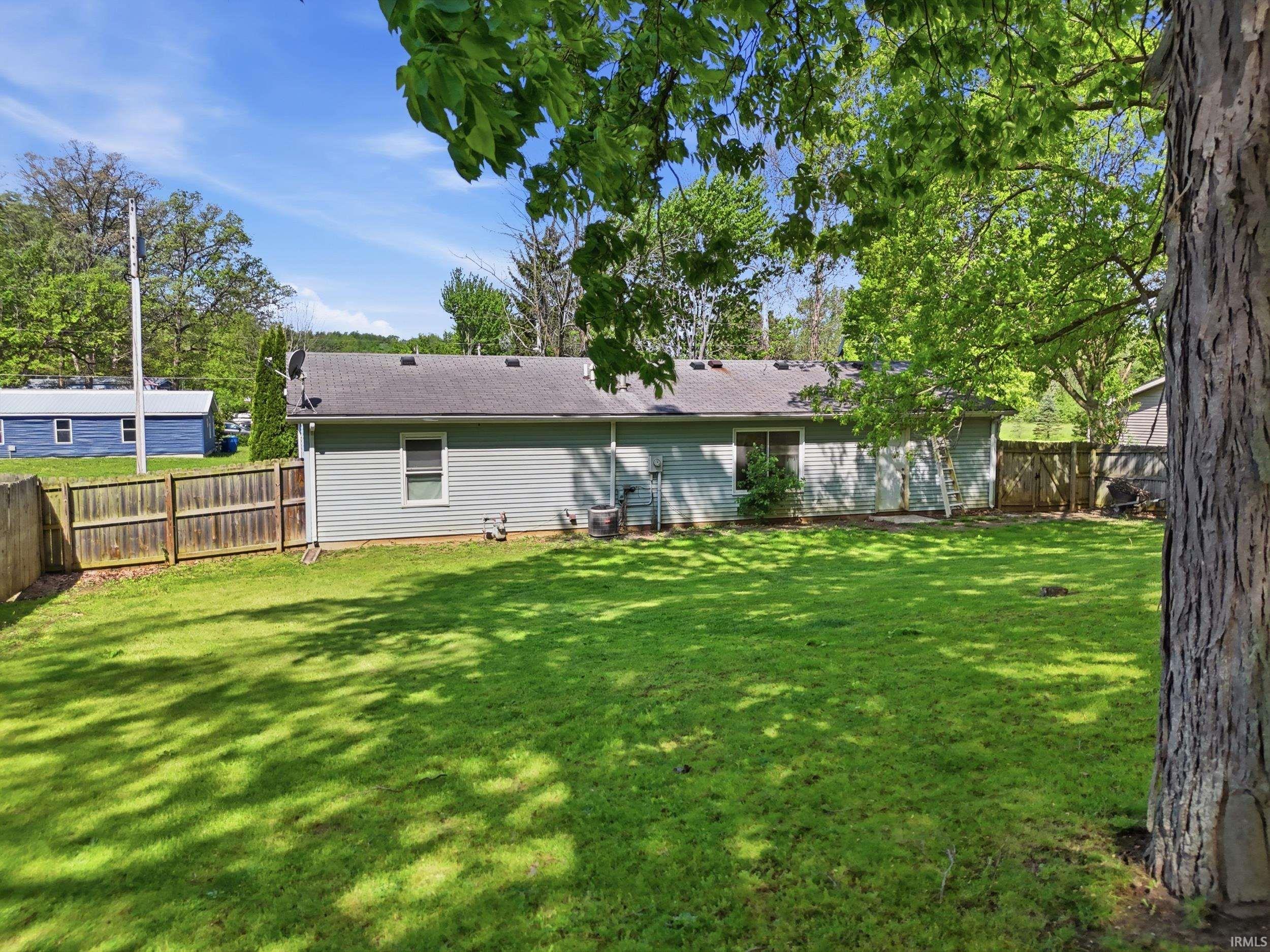 Expansive green lawn with a privacy fence