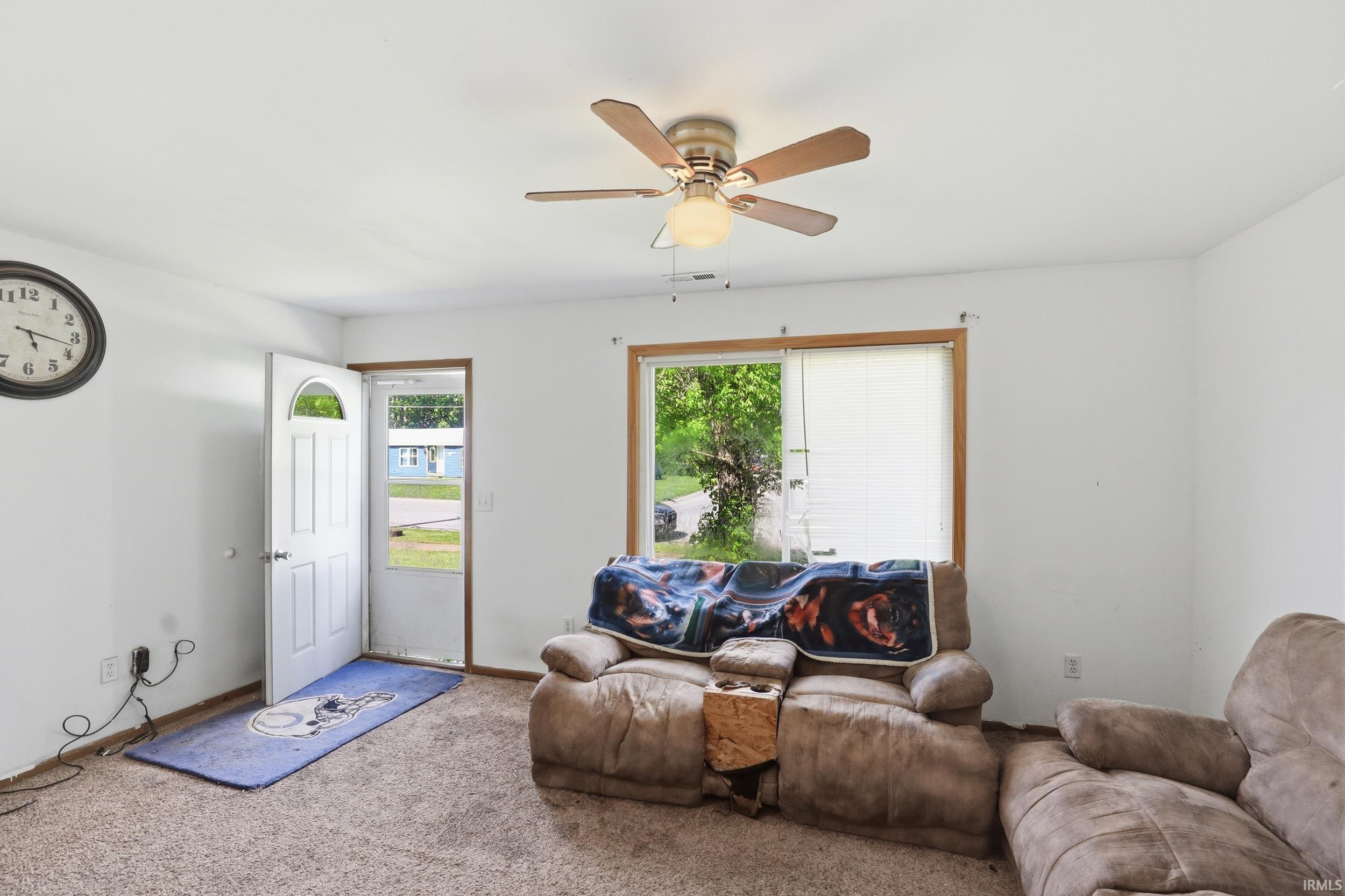 Light-filled interior space featuring carpet flooring and white walls