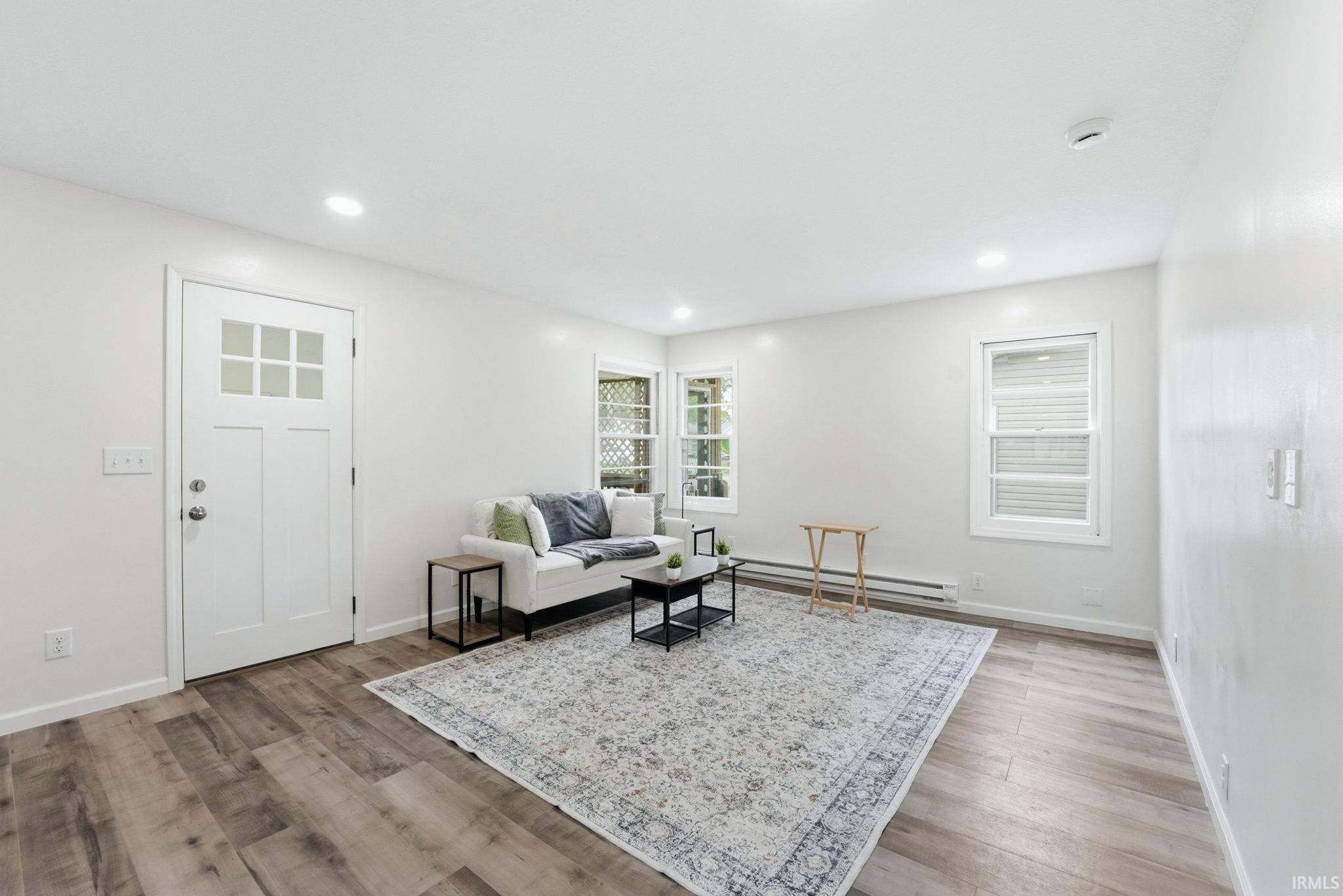 Bright living area featuring wood-finish flooring, recessed lighting, and multiple windows