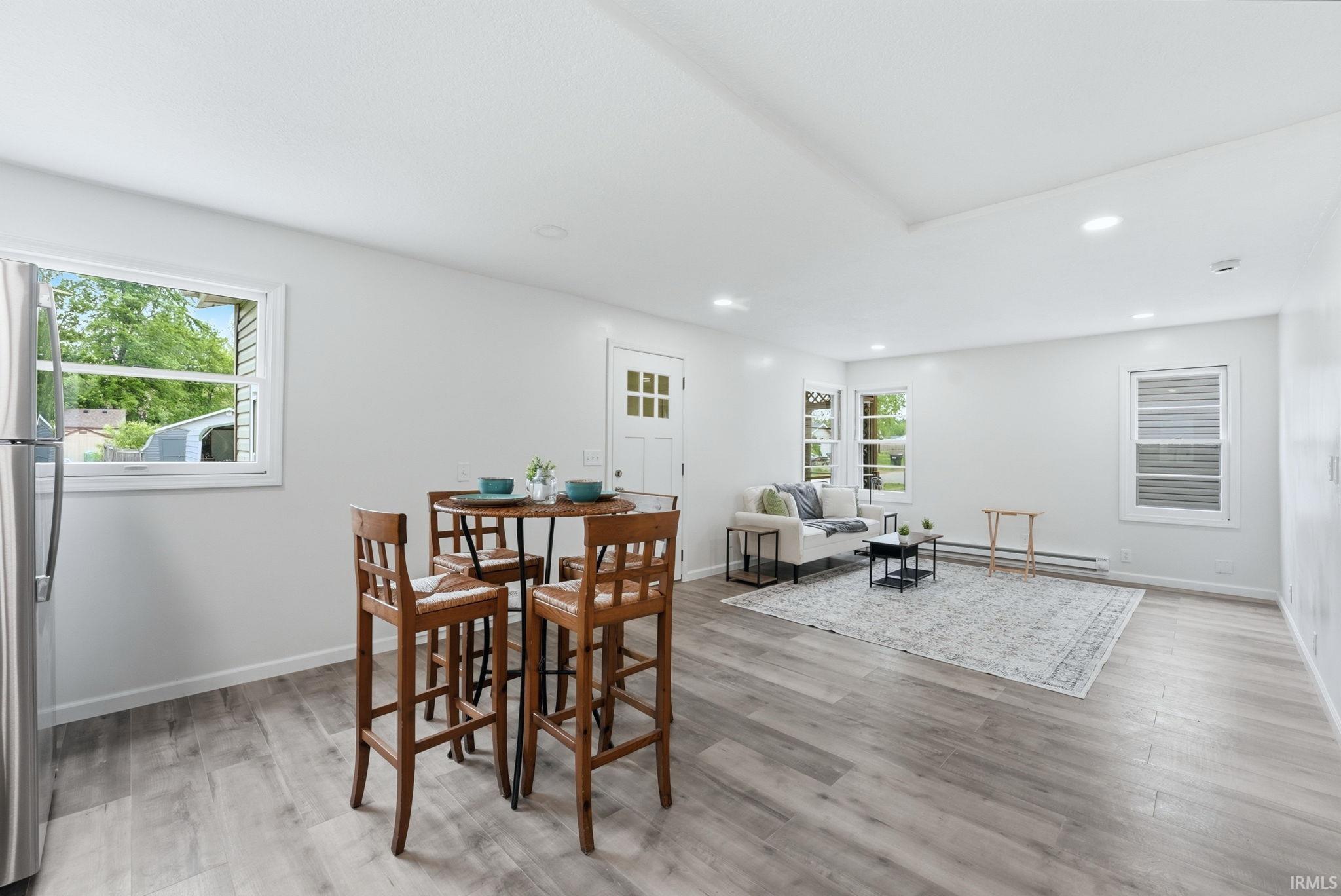 Open-concept interior featuring light gray wood-finish flooring, white walls, and recessed lighting