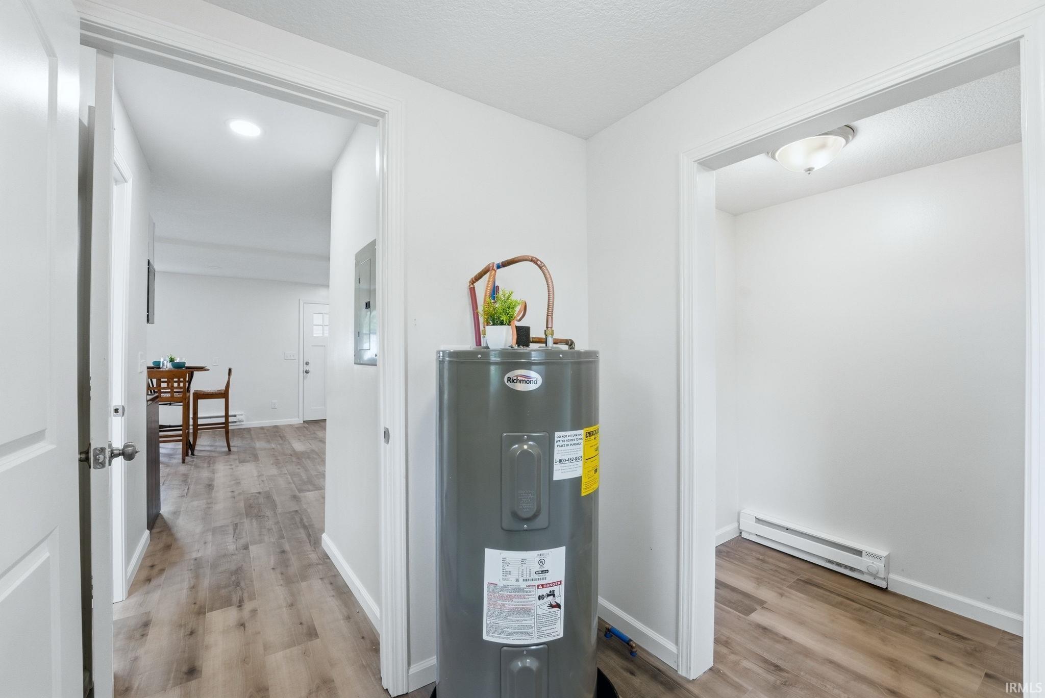 Interior hallway featuring wood-finish flooring, white walls, and a recessed ceiling light