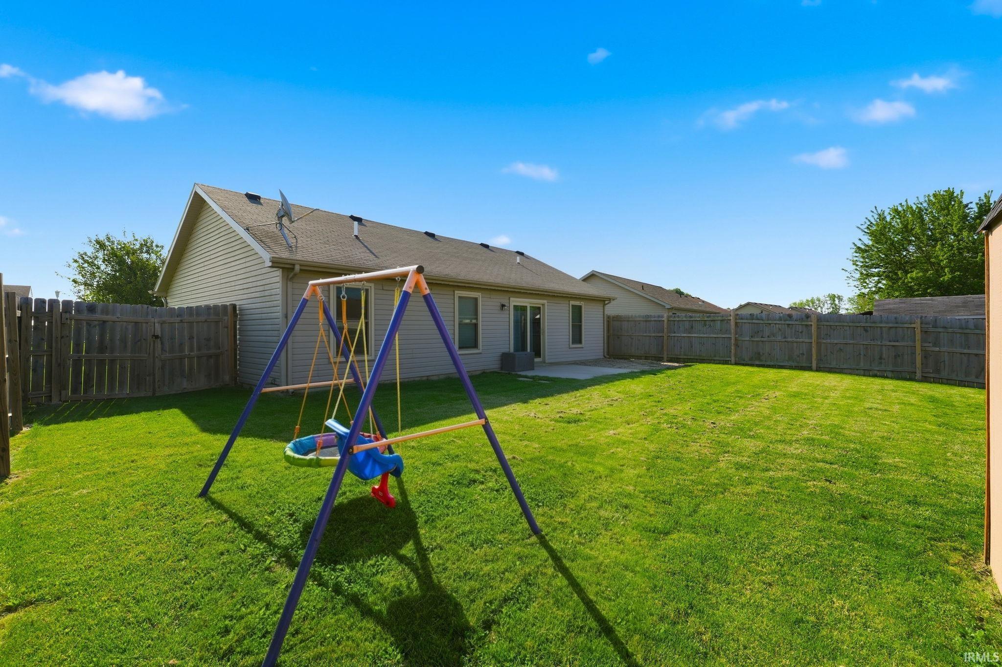 Expansive grass lawn bordered by a wood privacy fence