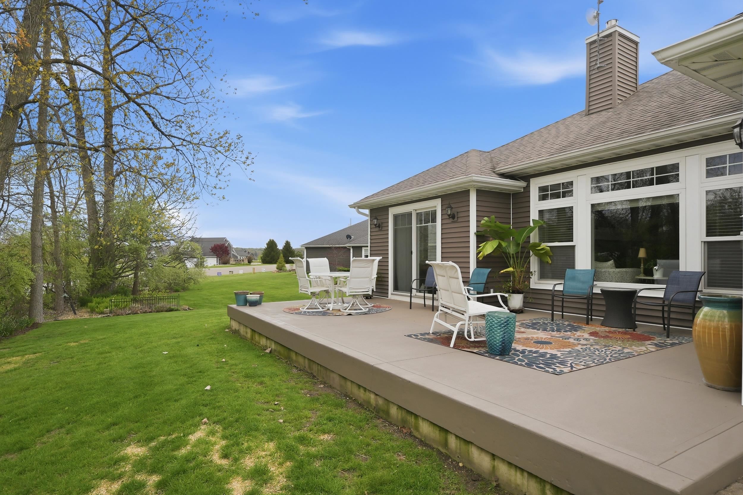 Expansive patio featuring a low-maintenance surface, direct outdoor access via sliding glass door, and large windows providing abundant natural light