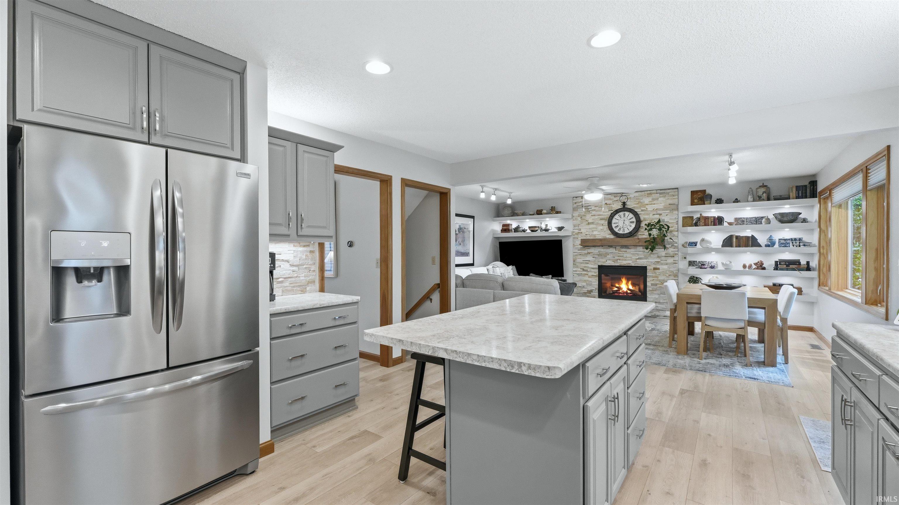 Open-concept living space featuring a kitchen with gray cabinetry and stainless-steel appliances