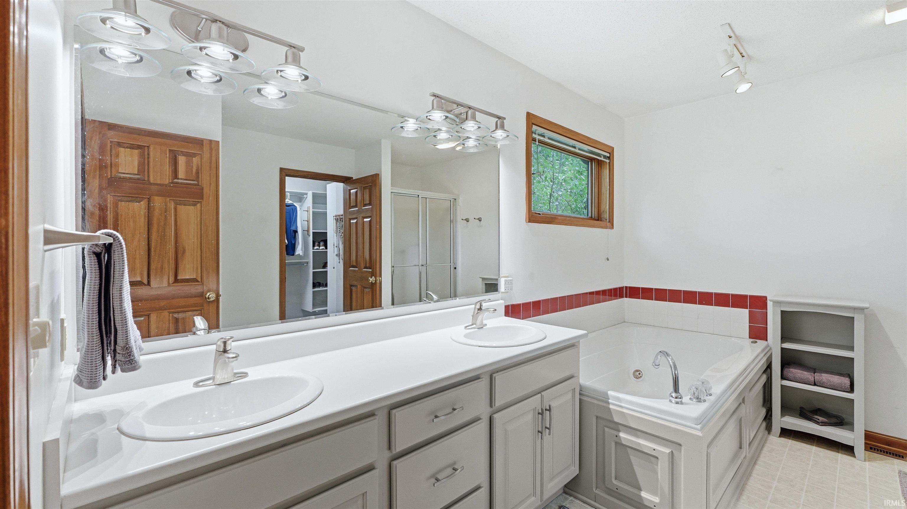 Bathroom featuring a dual vanity with white countertops, integrated sinks, and light gray cabinetry