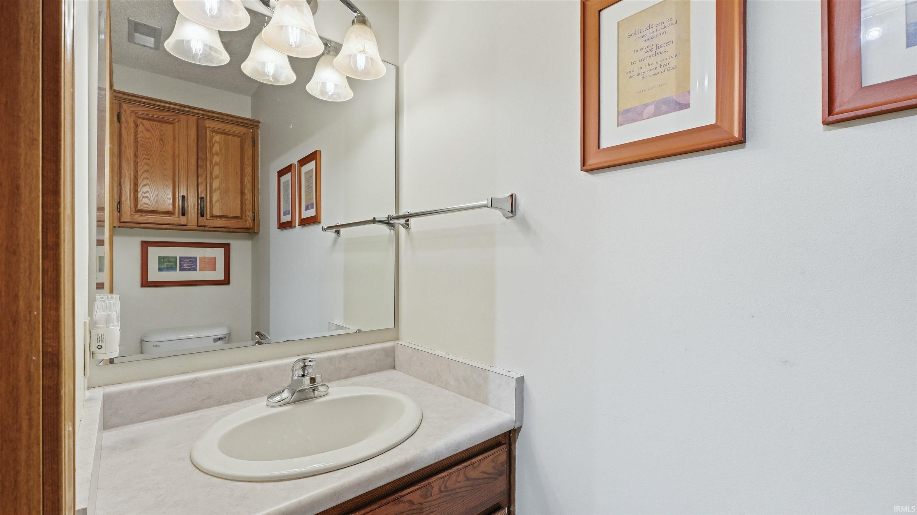 Vanity with an integrated sink and light-toned countertop, featuring a chrome faucet