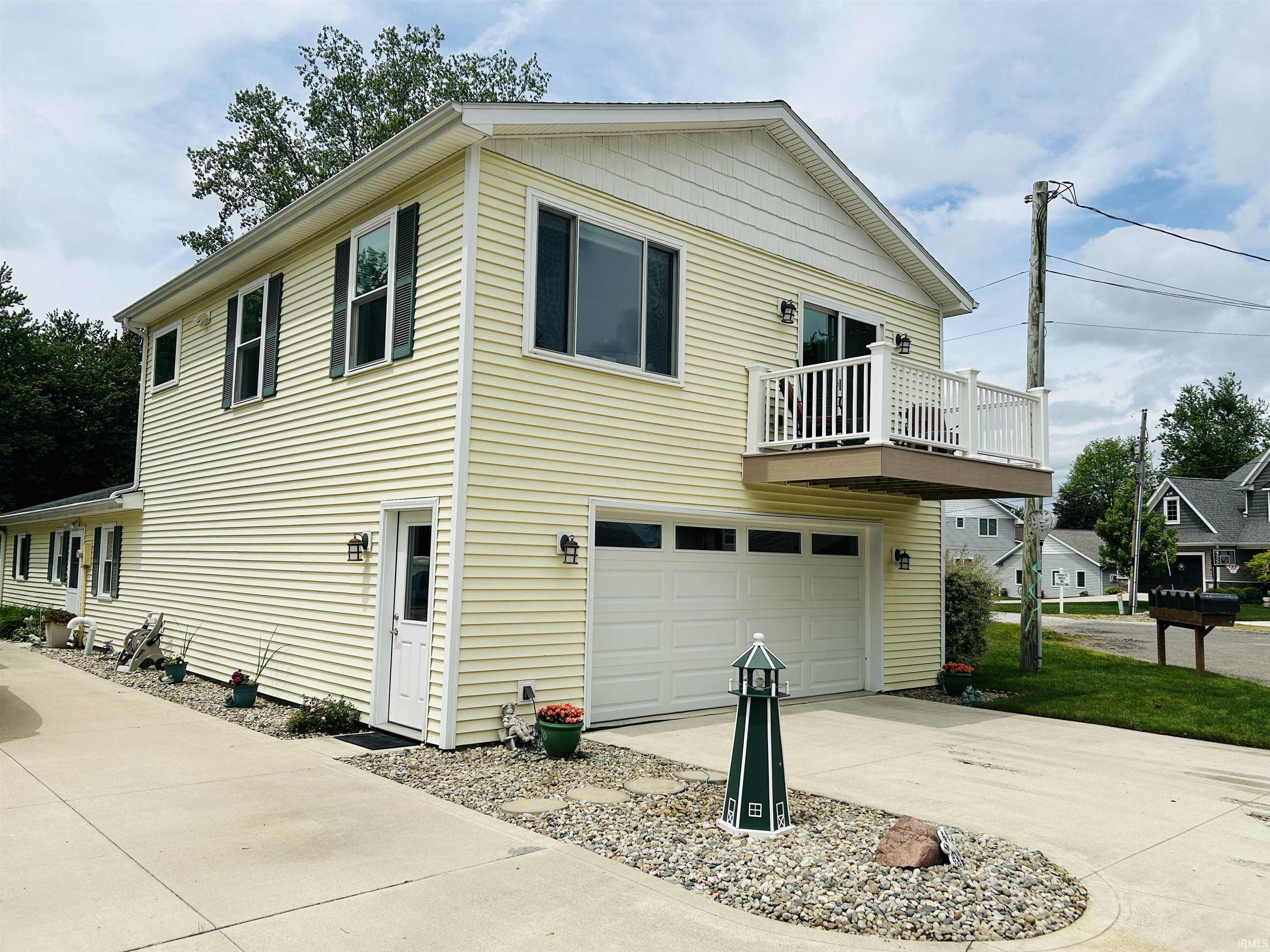 Two-story residence featuring light yellow siding and a white trim