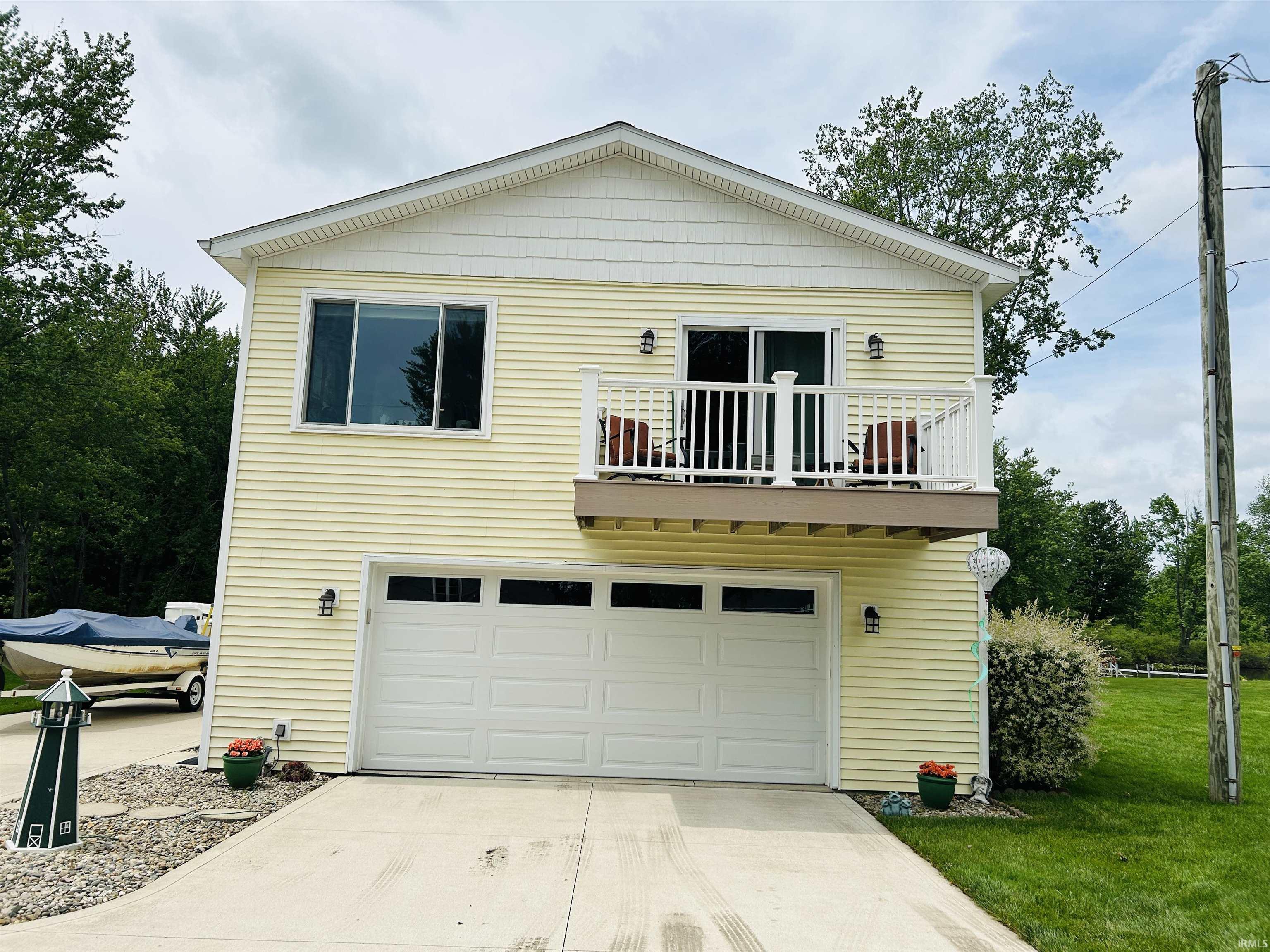 Two-story residence featuring yellow horizontal siding and white trim