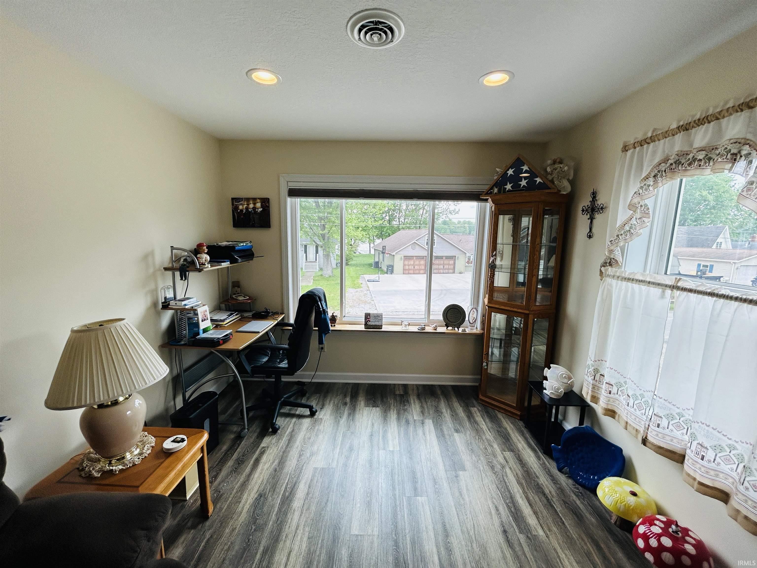 Spacious interior room featuring wood-finish flooring, recessed lighting, and a large picture window
