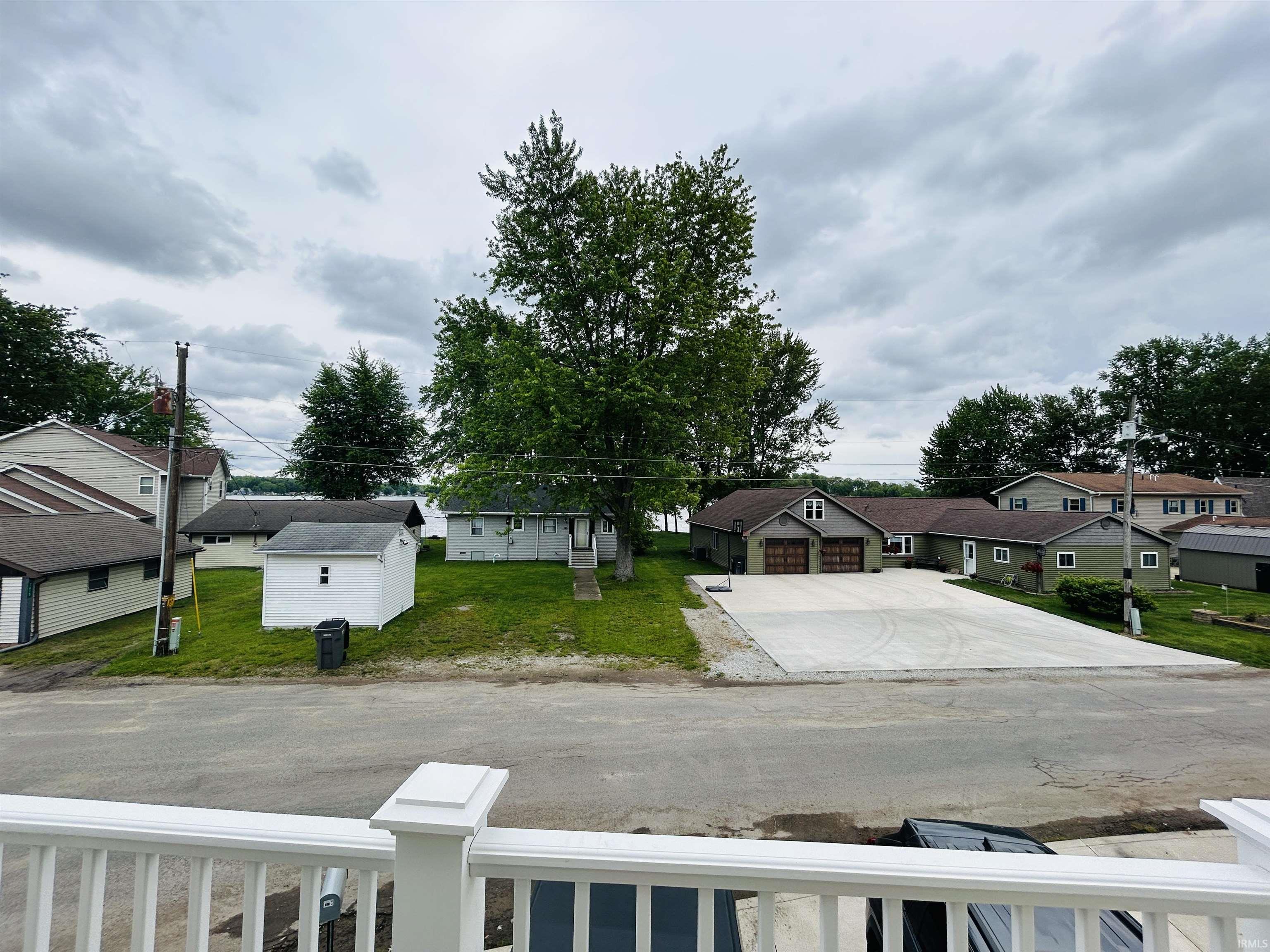 Property featuring a light green exterior, an attached garage with two bay doors, and a substantial concrete driveway