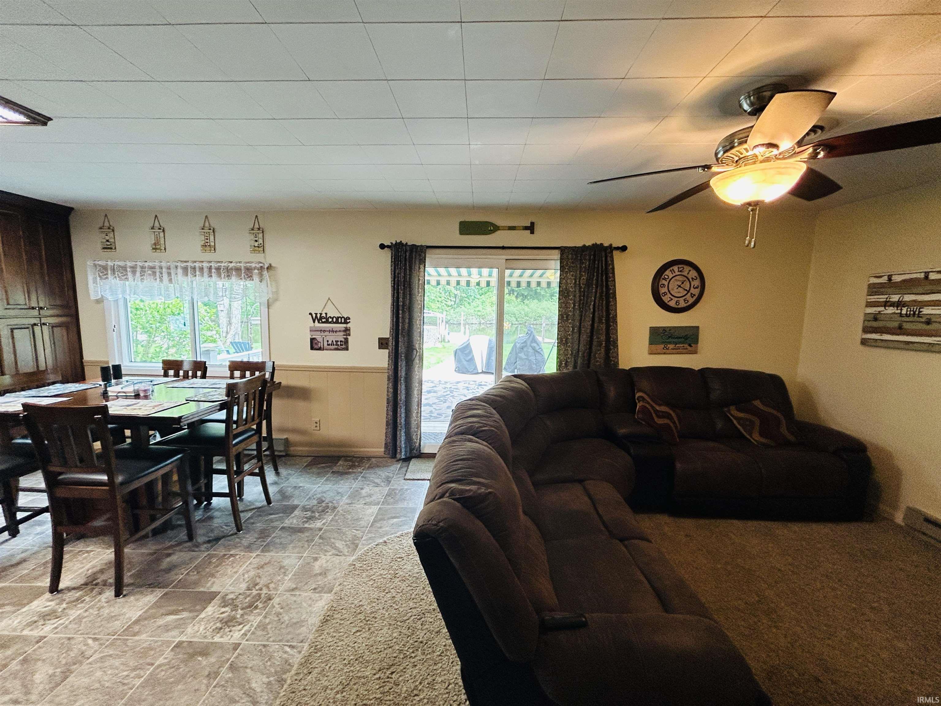 Dining area with wood-finish cabinetry, tile flooring, and a large window