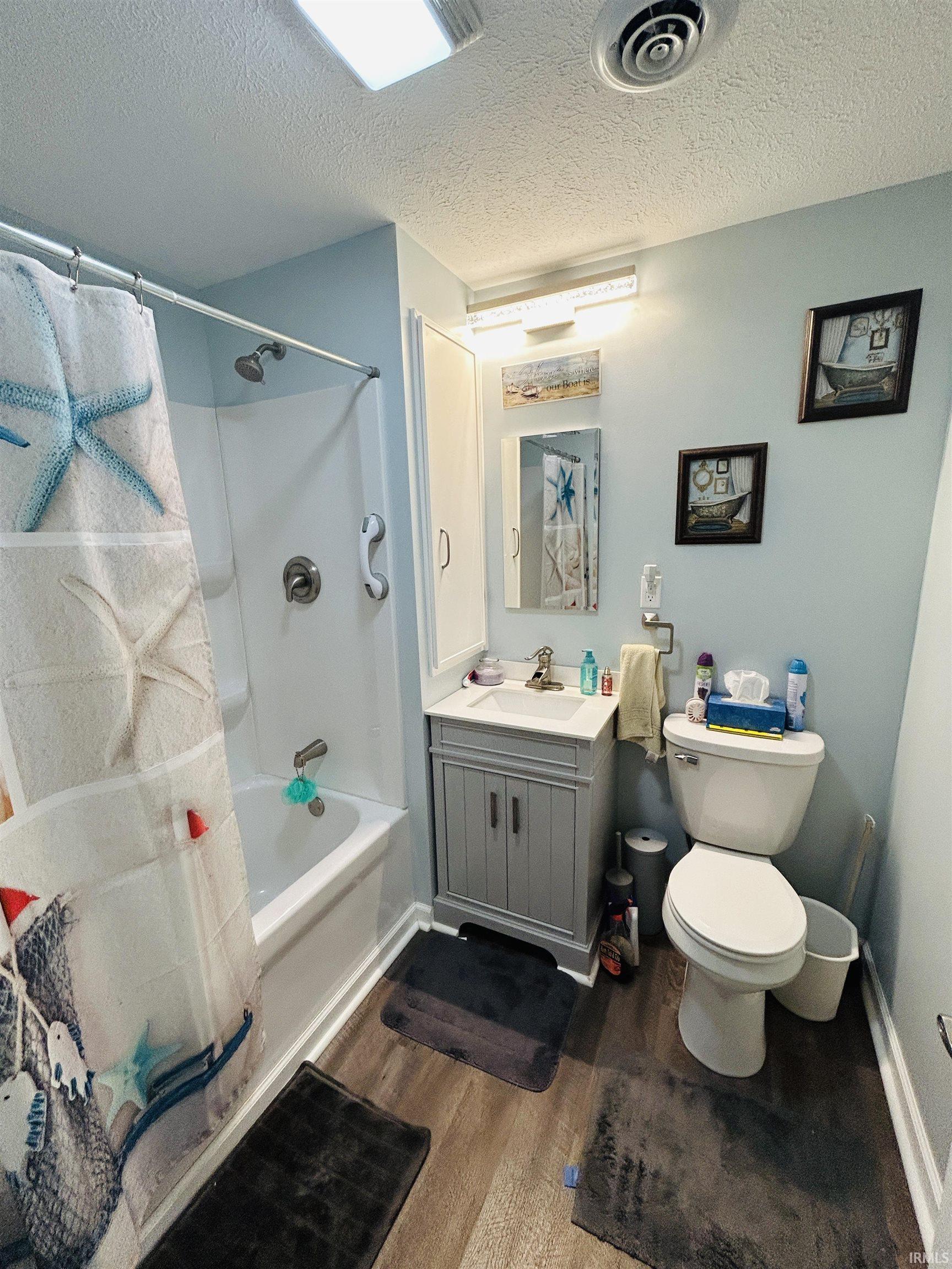 Bathroom featuring wood-finish flooring and light blue walls