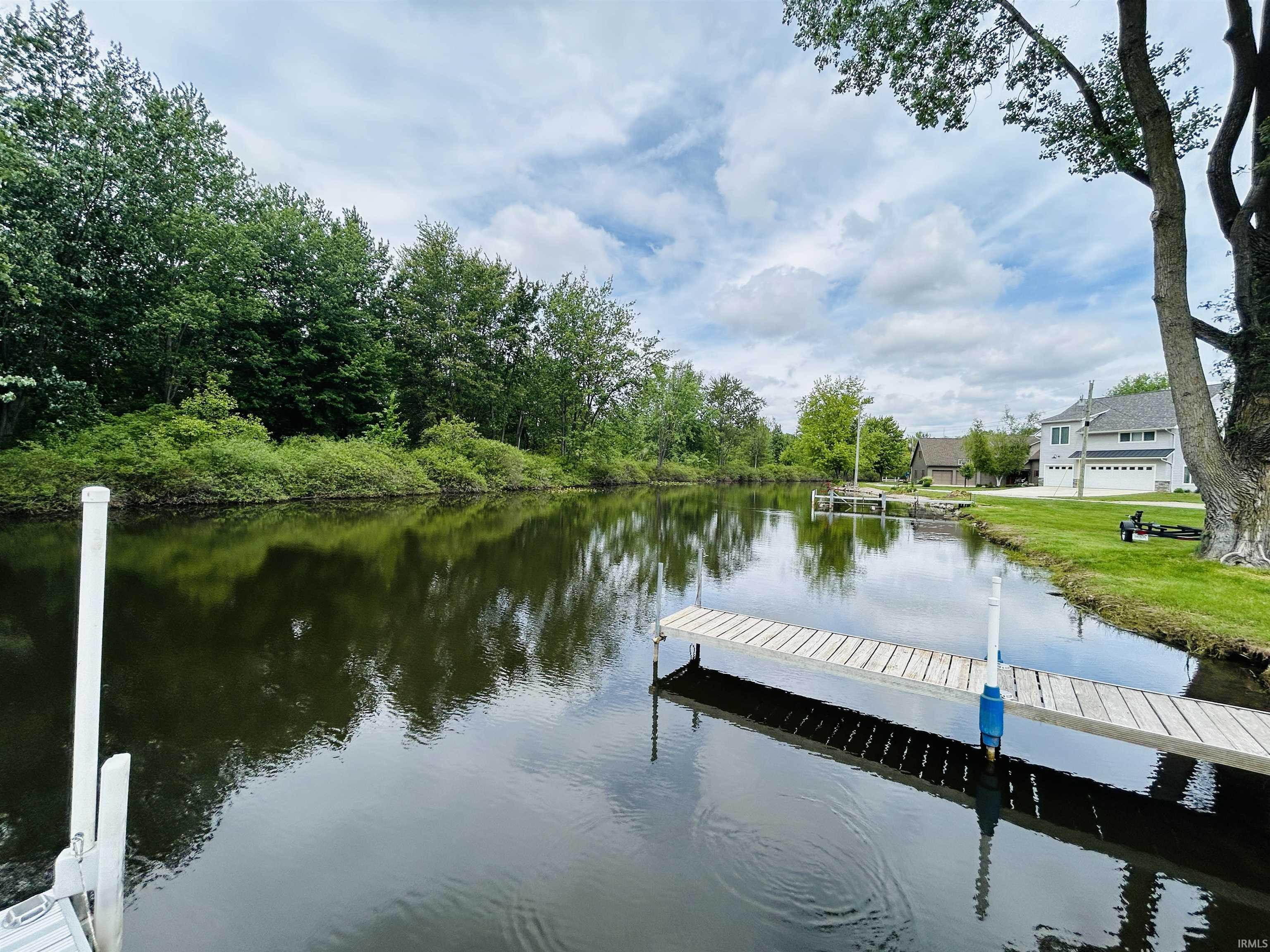 Waterfront property featuring a private wooden dock and lush green banks