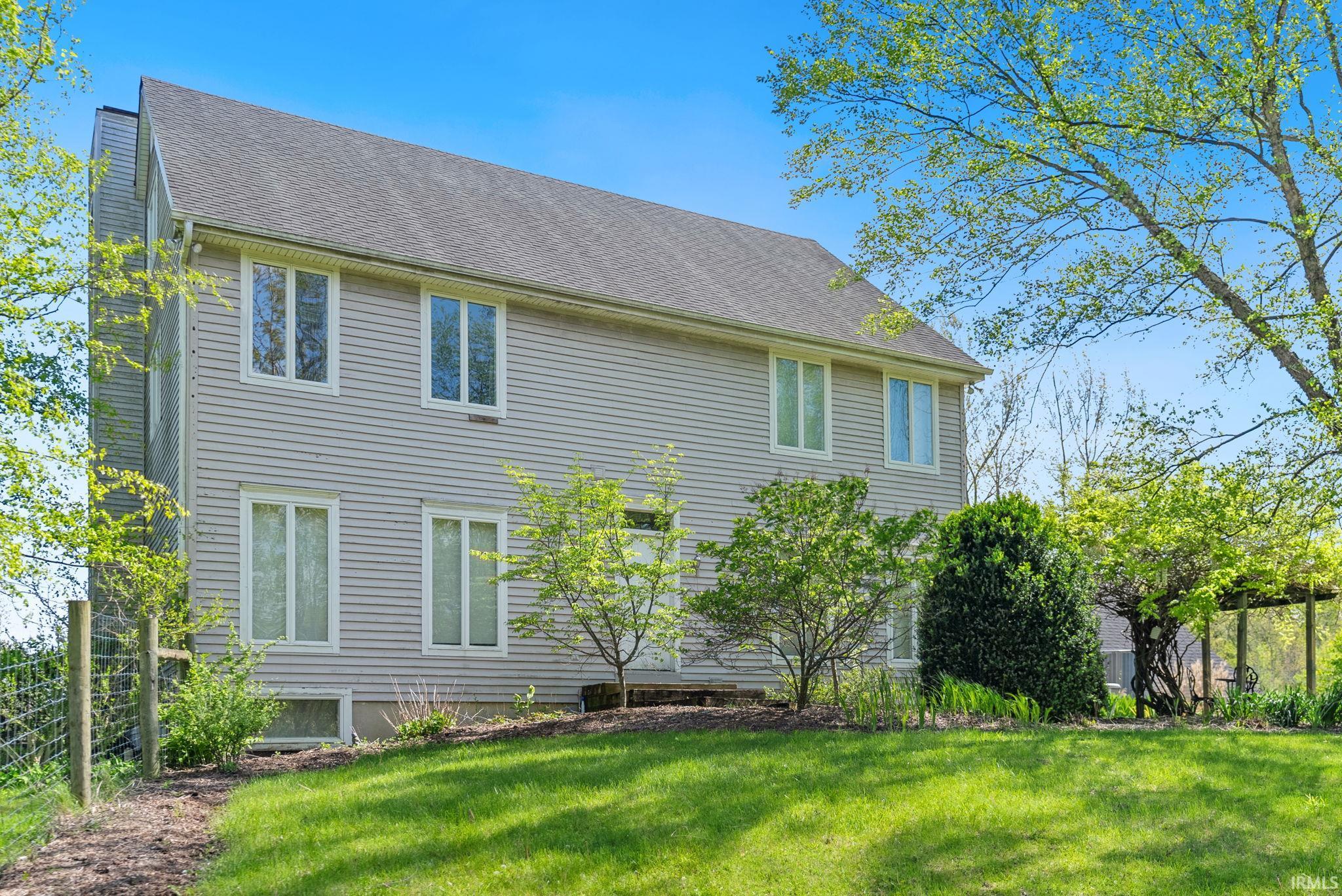 Two-story residence featuring light-colored horizontal siding and a dark-toned gable roof