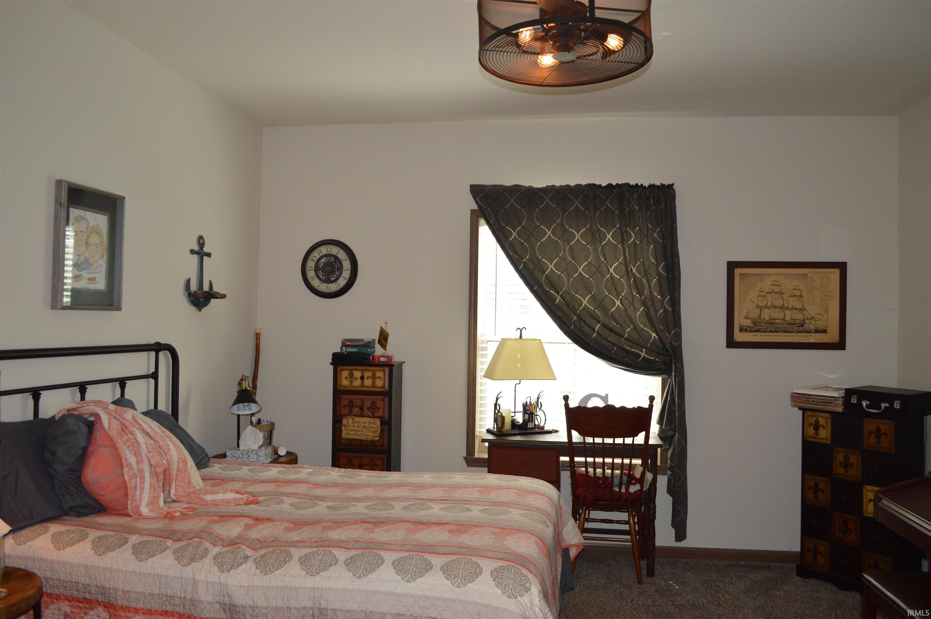 Carpeted room featuring a ceiling-mounted light fixture, window with curtains, and light-toned walls
