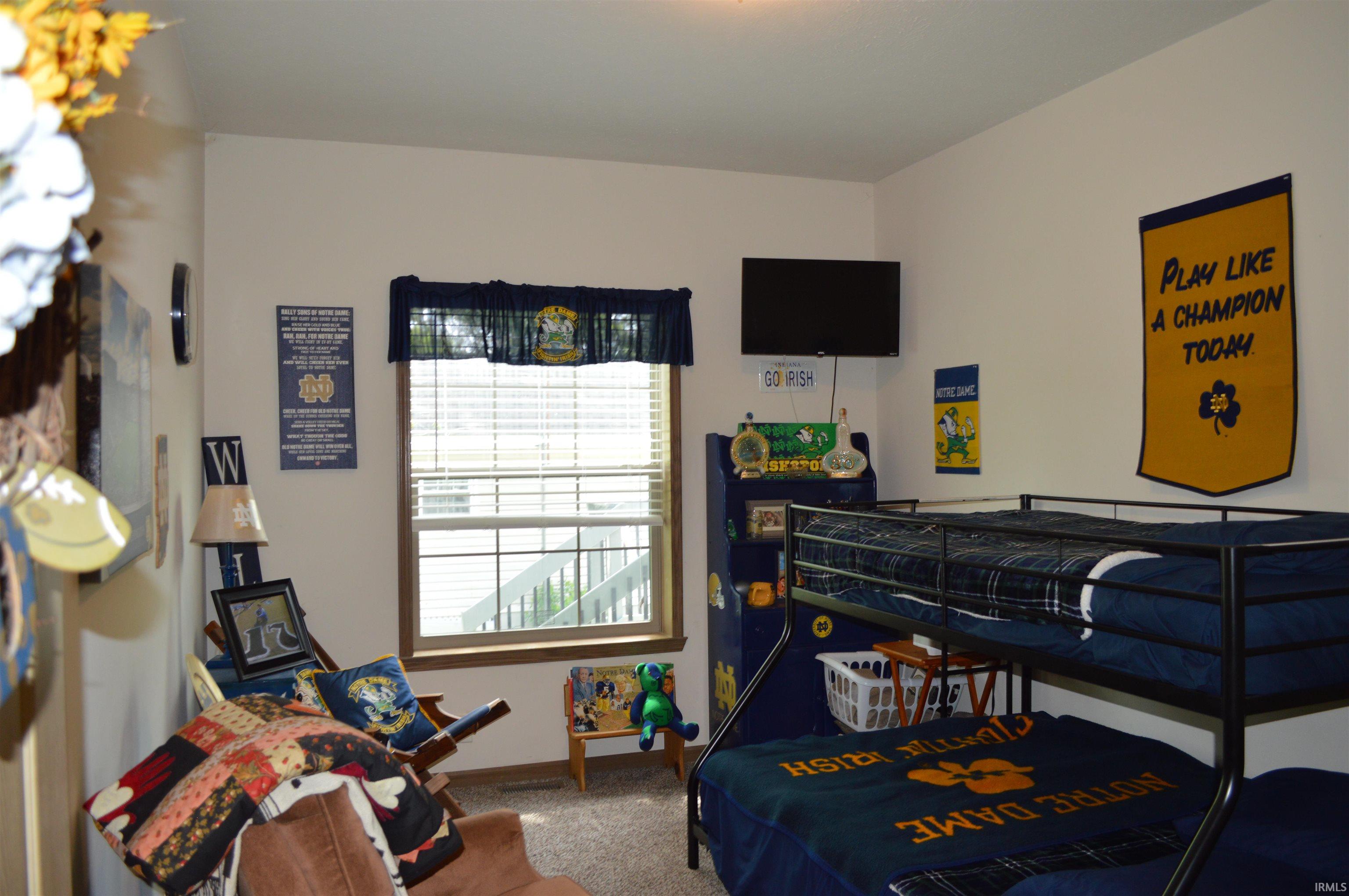 Well-lit room featuring a window with horizontal blinds and a fabric valance