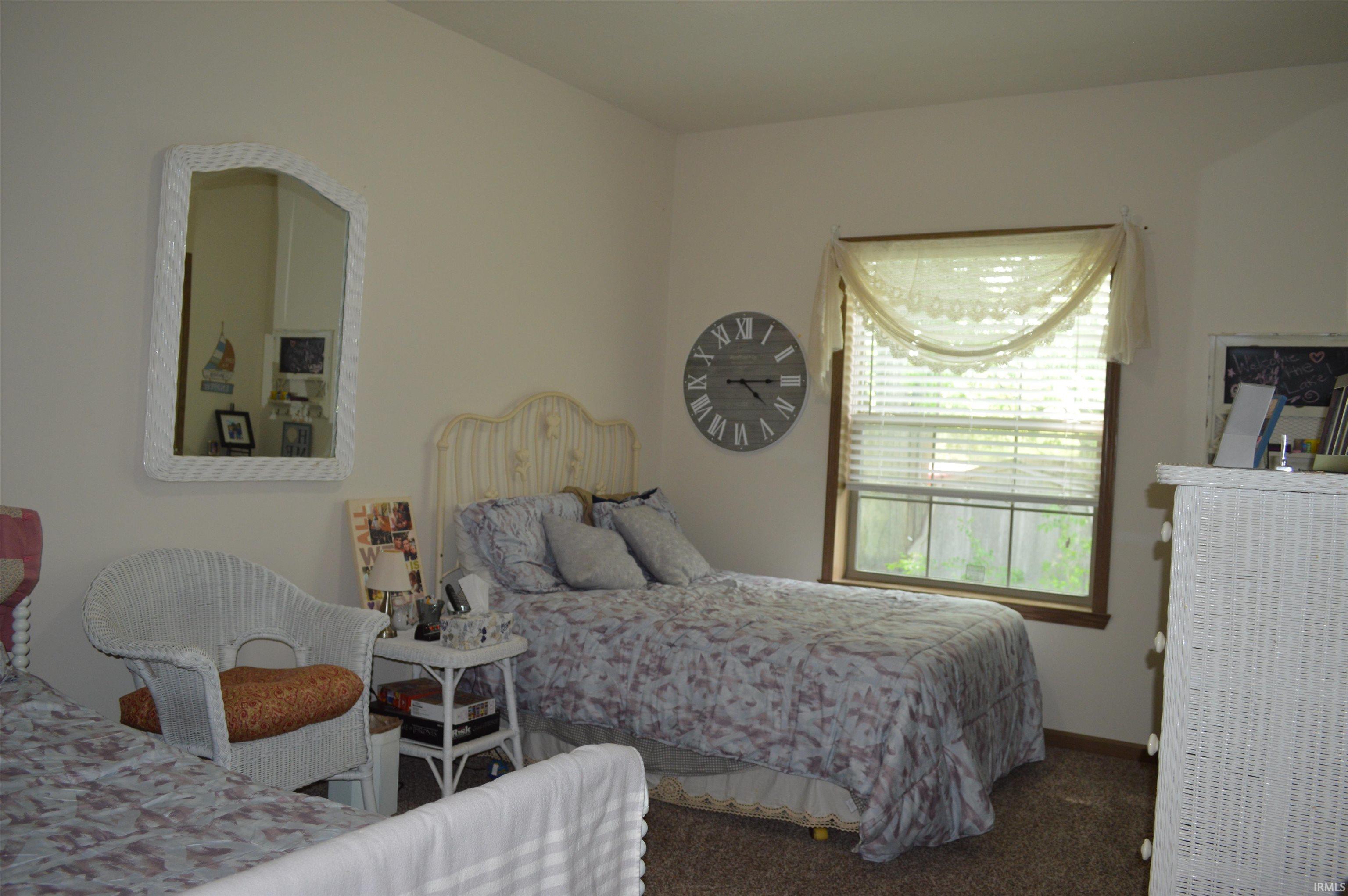 Room featuring a single window with blinds, neutral wall paint, and brown carpet flooring