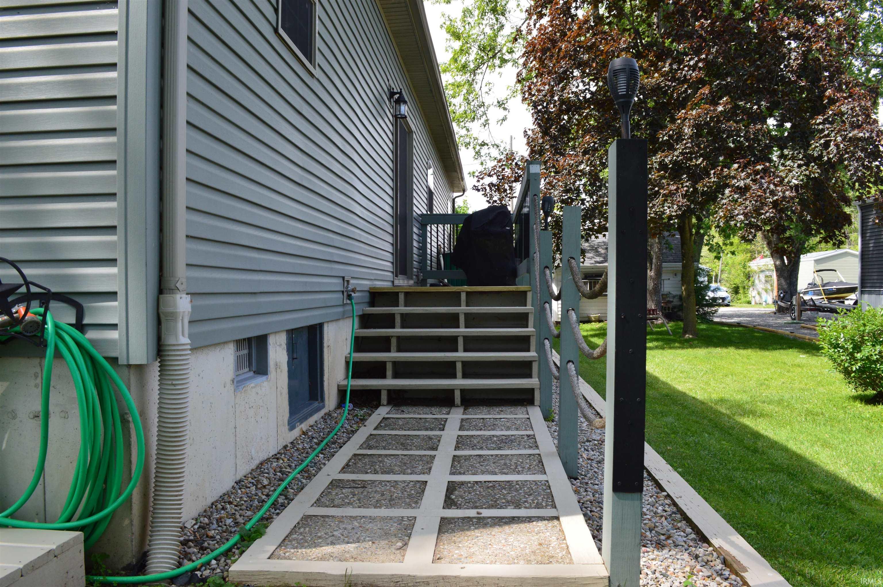 Side exterior featuring horizontal siding and a concrete foundation