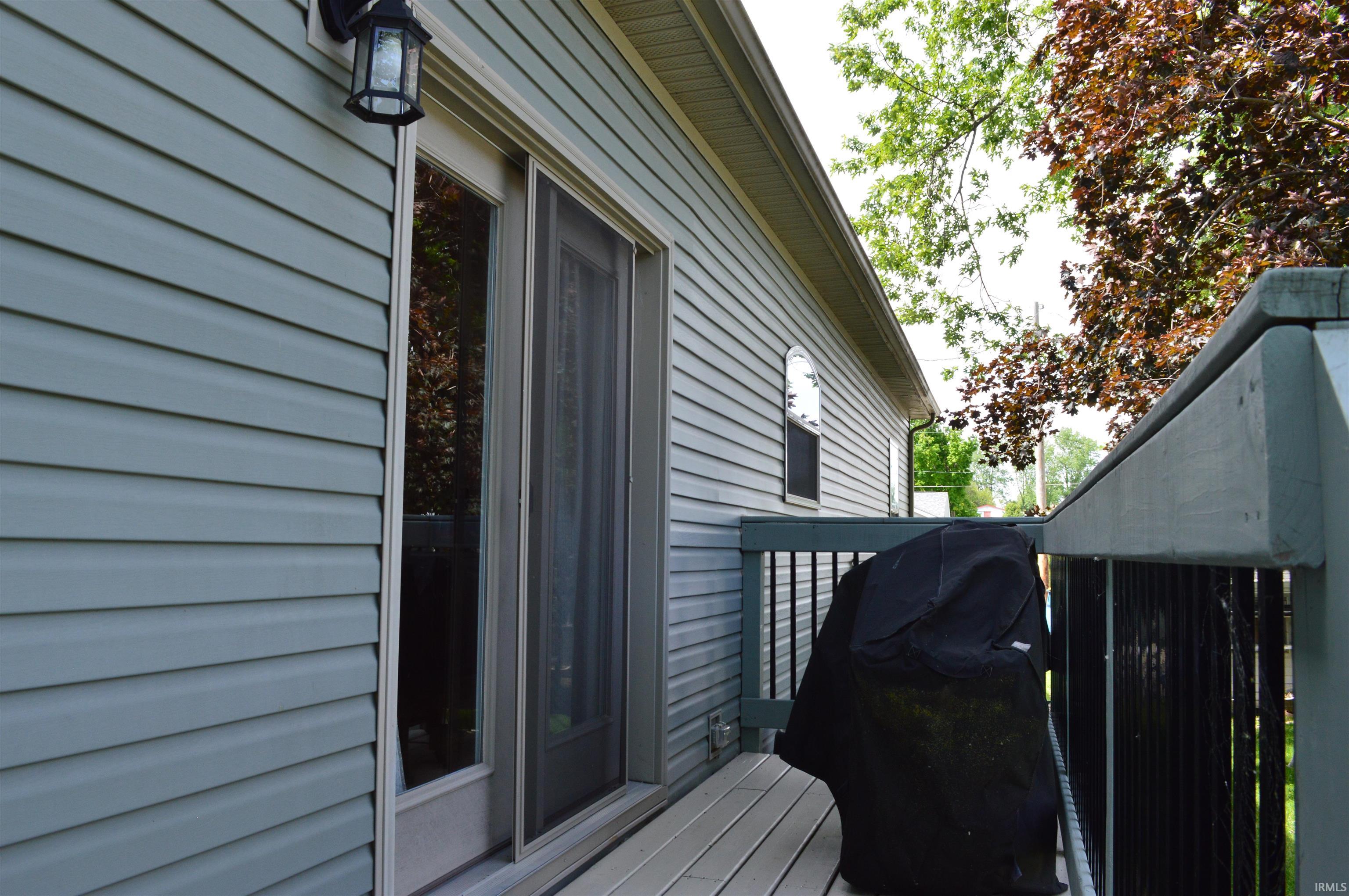 Exterior deck featuring composite decking, painted wood railing, and a direct entrance to the property via a sliding glass door