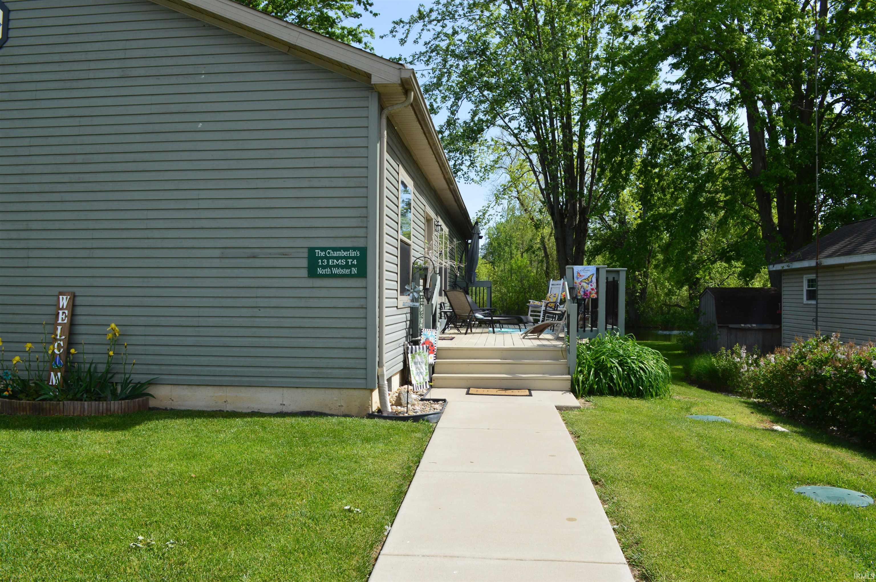 Exterior featuring horizontal siding, a concrete walkway, and a wooden deck