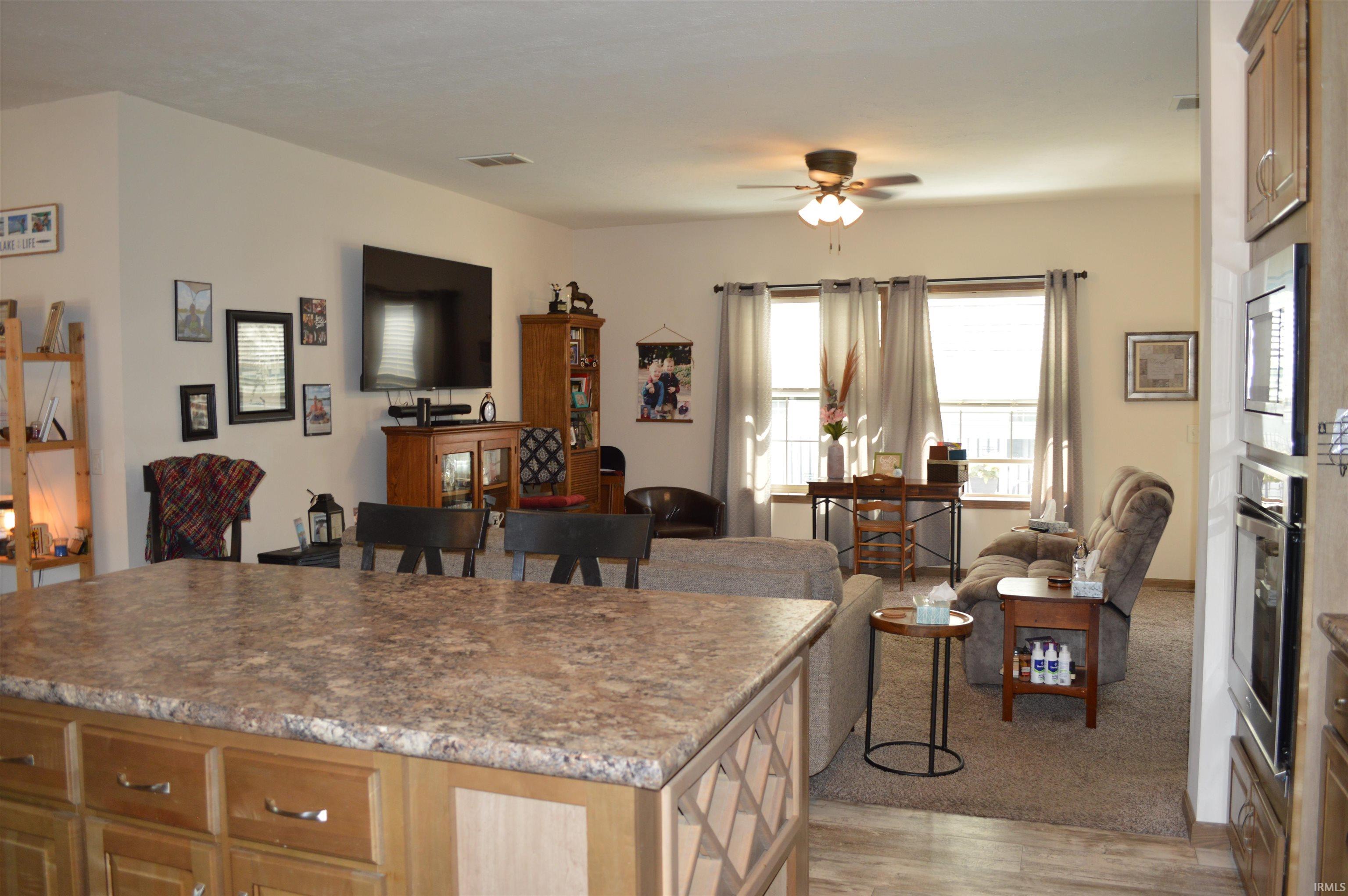Expansive kitchen island with laminate countertop and wood cabinetry