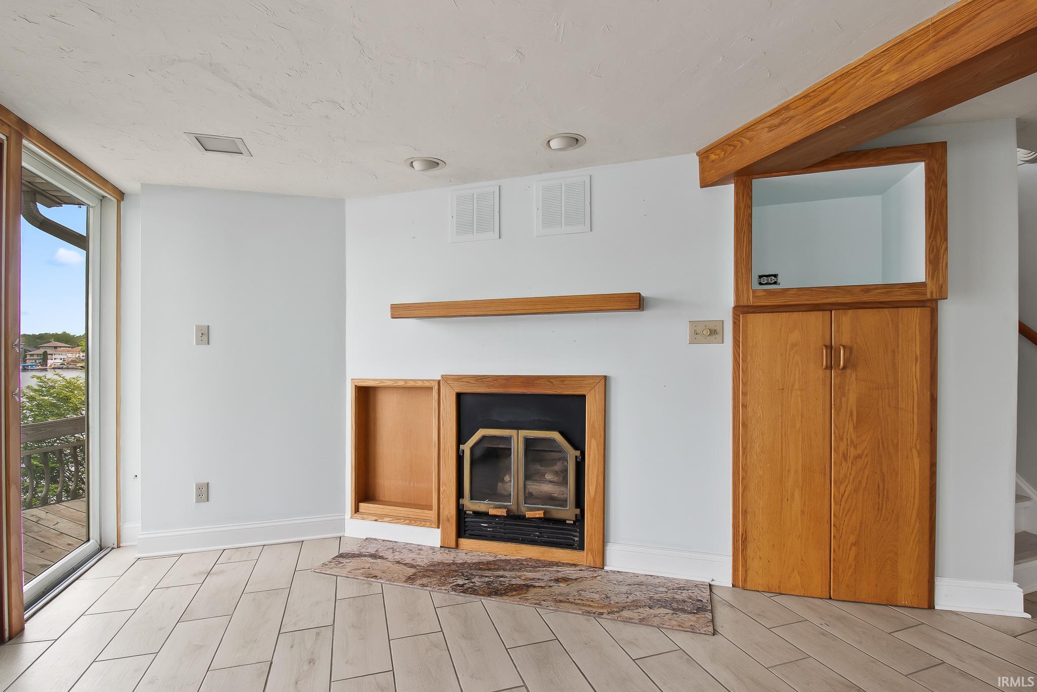 Room featuring light wood-finish plank flooring and a sliding glass door leading to an outdoor deck