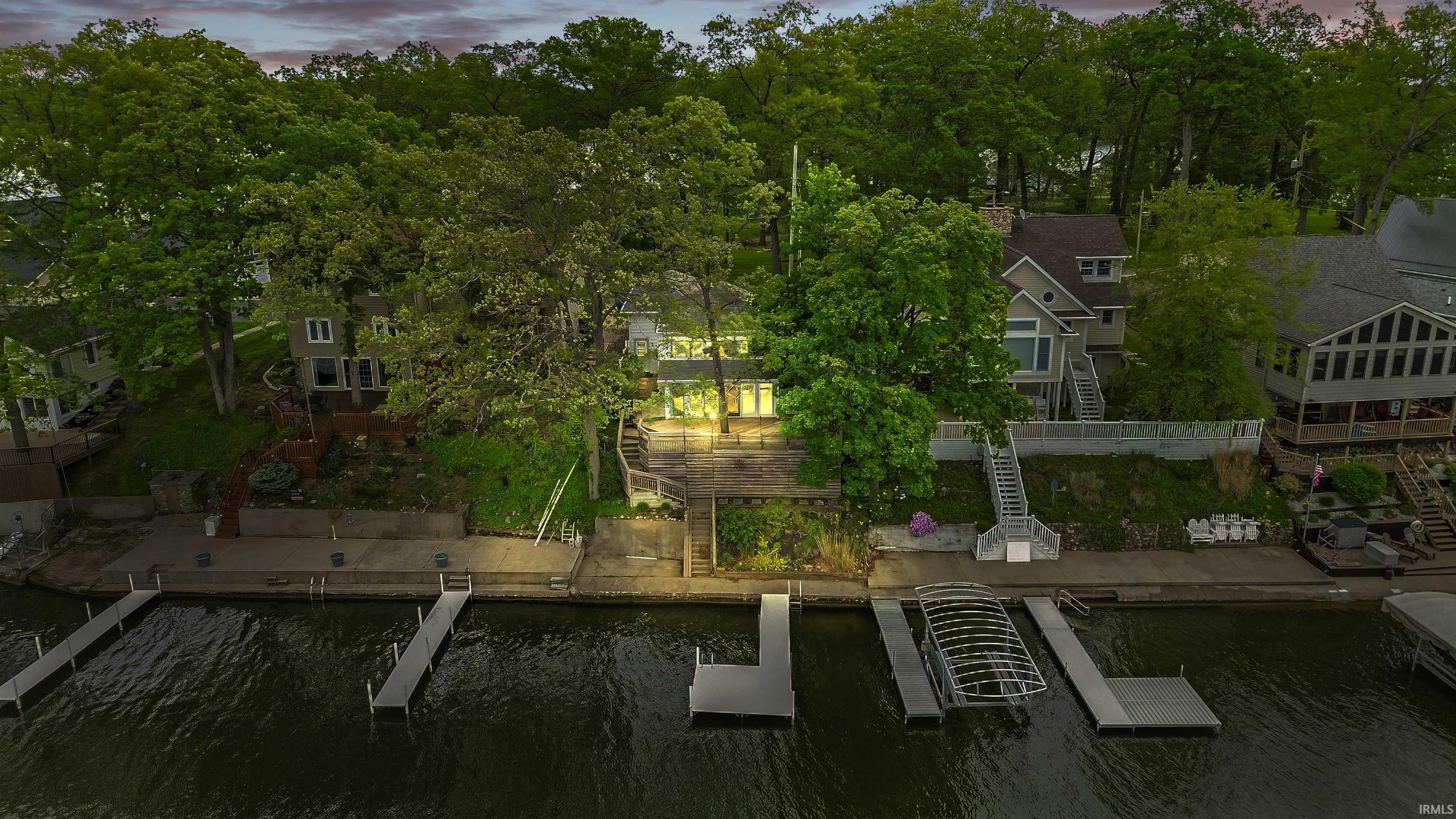 Waterfront property featuring a private dock, boathouse, and mature trees