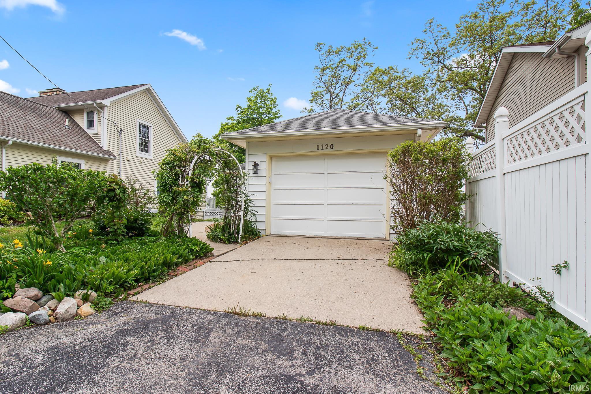 Attached garage featuring a white paneled door and numerical address