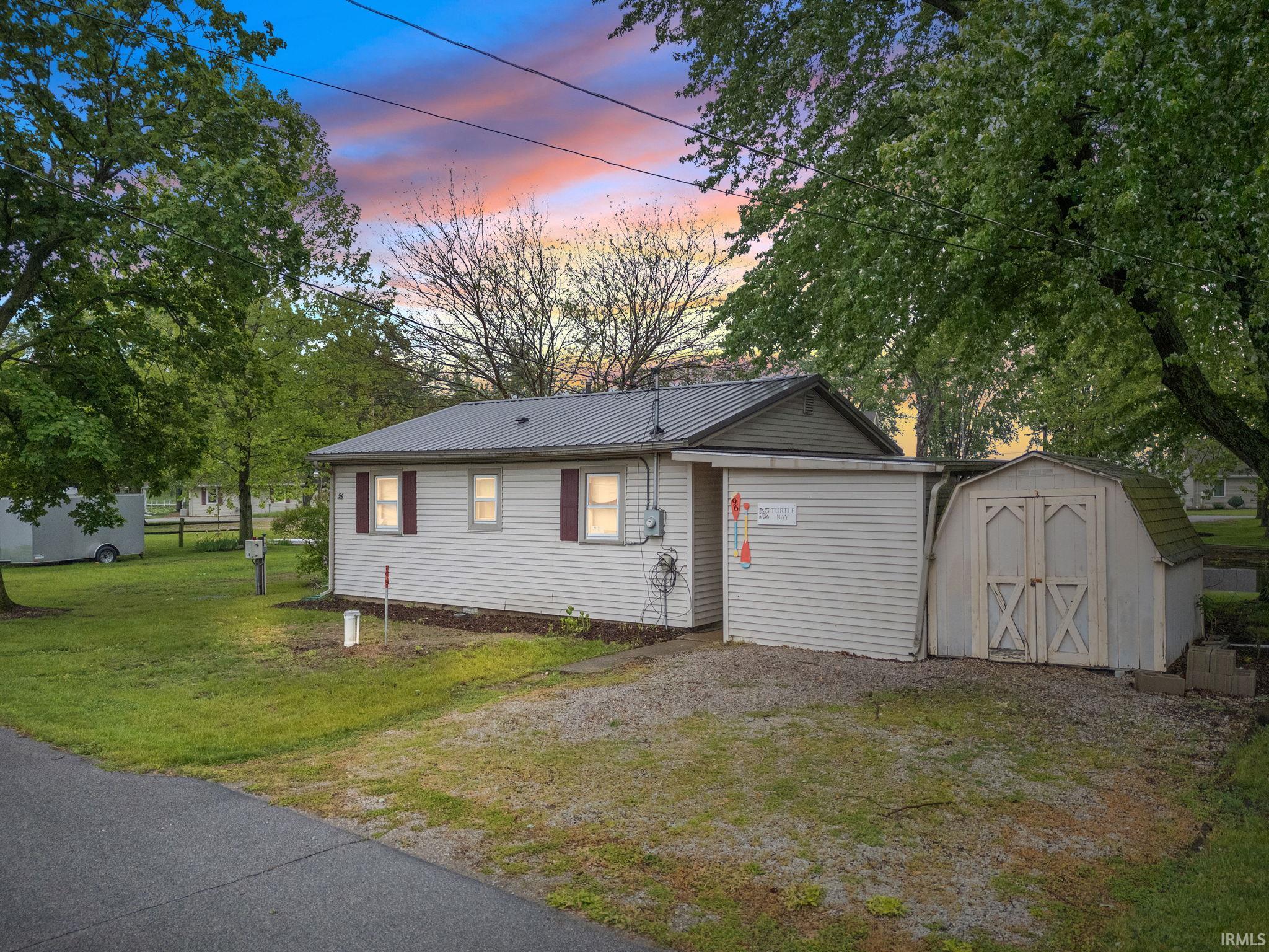 White vinyl siding home with a metal roof