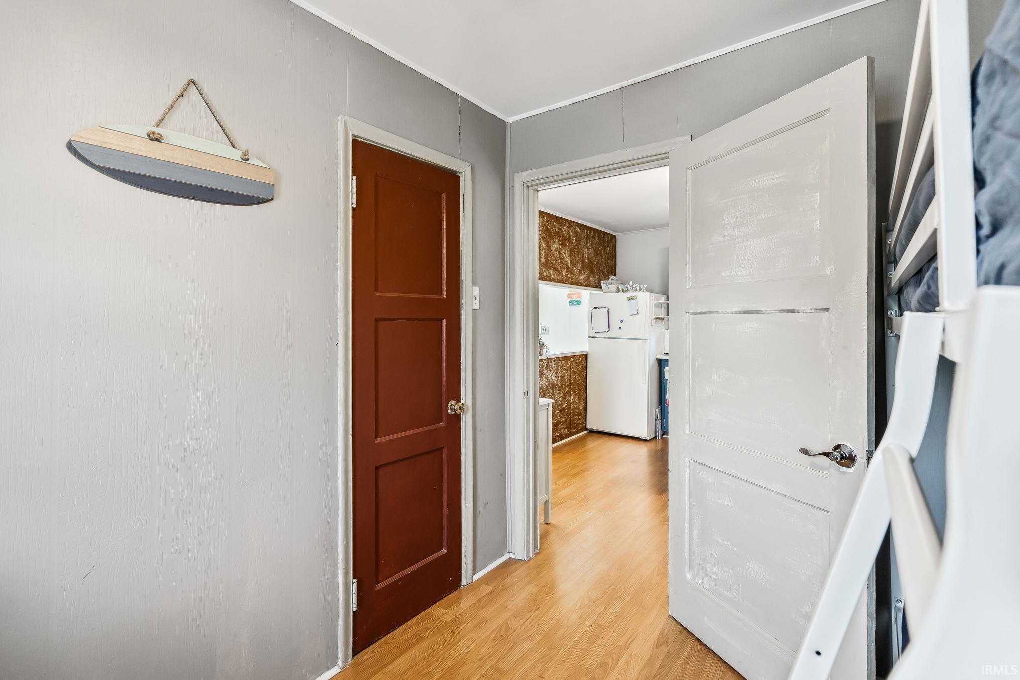 Entryway featuring wood-finish flooring, a solid panel interior door, and light gray wall finishes