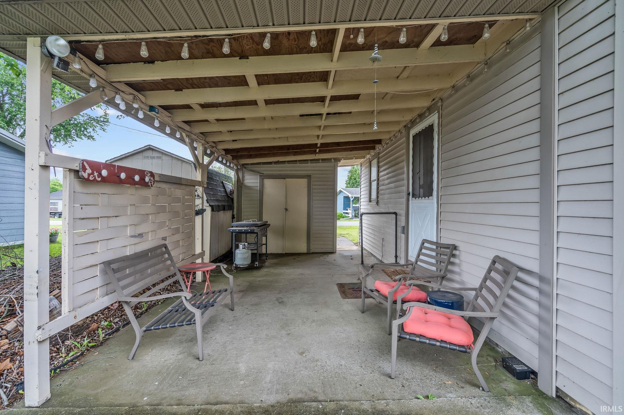 Covered patio featuring a concrete slab and exposed wood ceiling