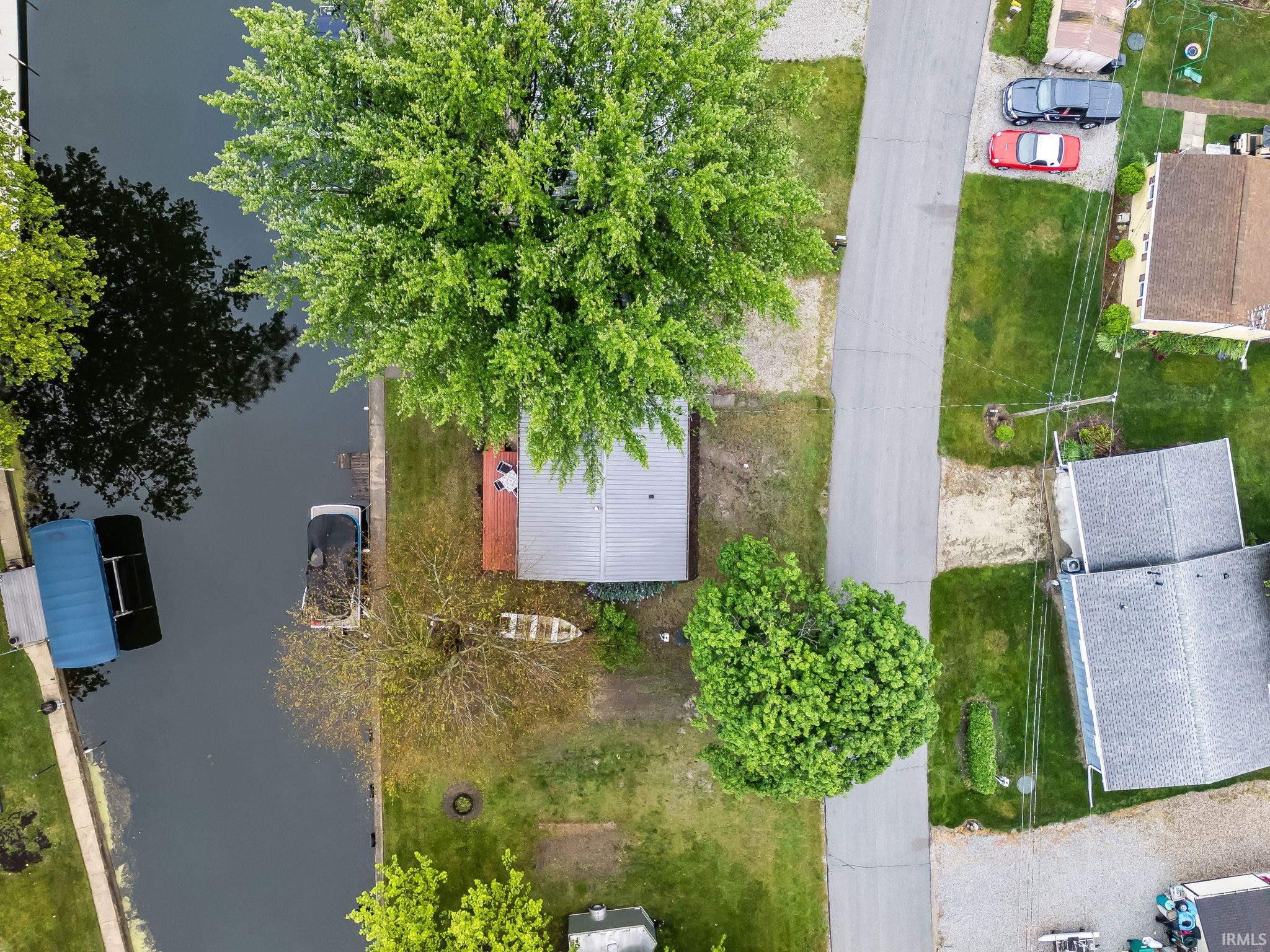 Waterfront property featuring a private boat dock, mature trees, and direct canal access