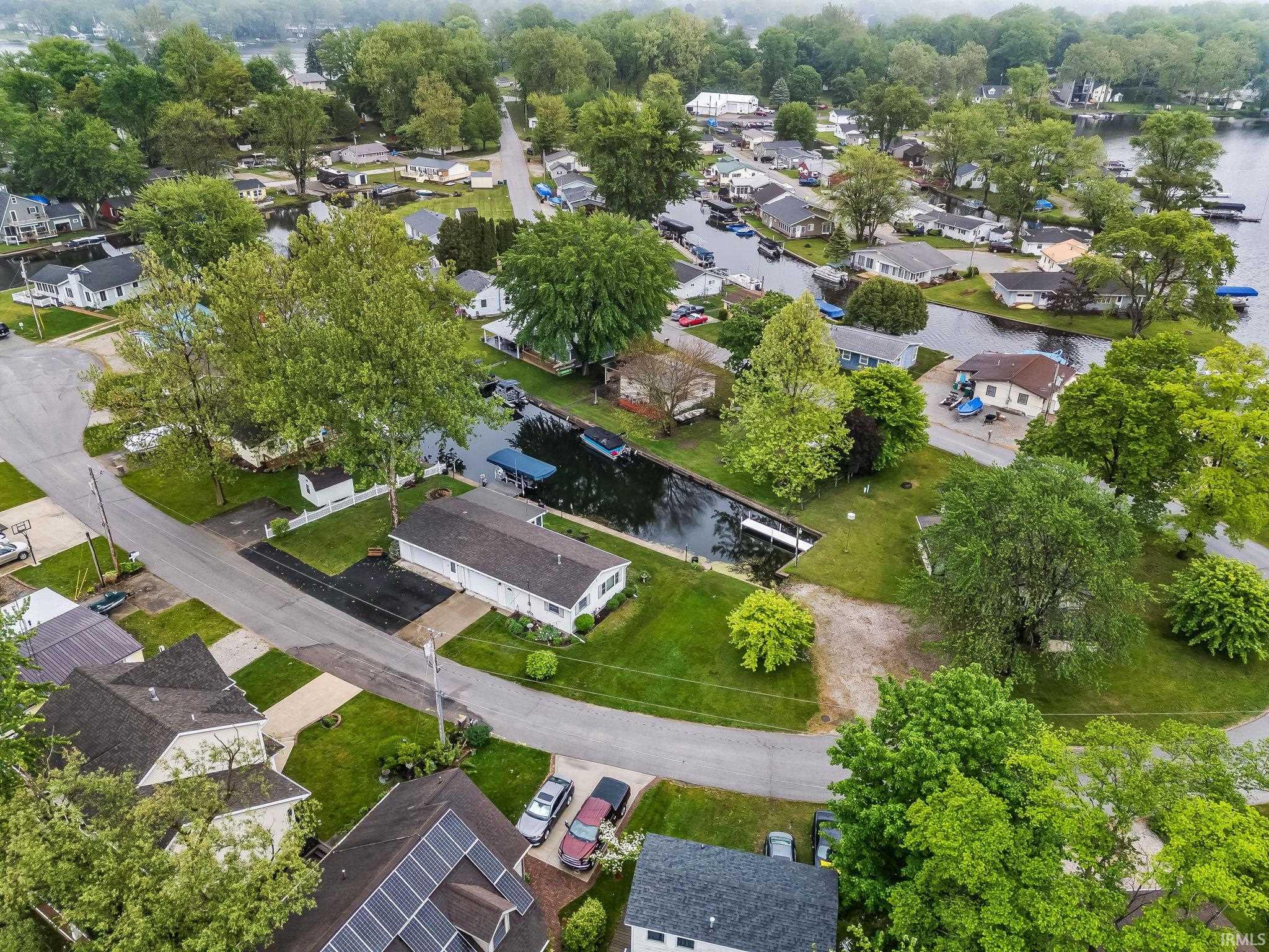 Aerial perspective showcasing a residential area with canal access, mature trees, and individual boat docks