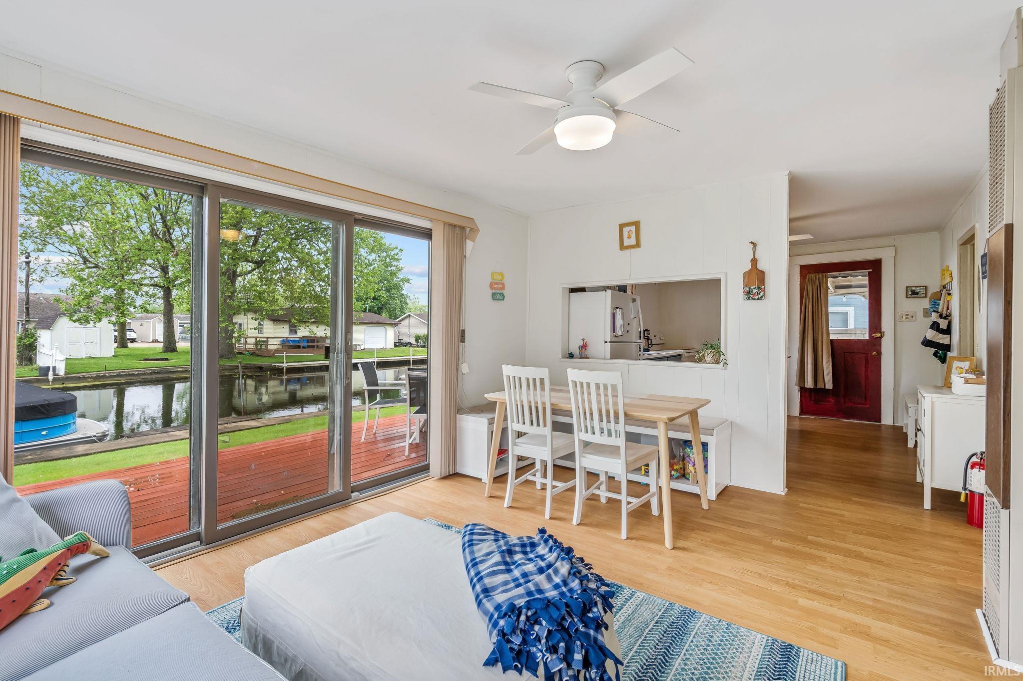Bright interior with wood-finish flooring and a white ceiling fan