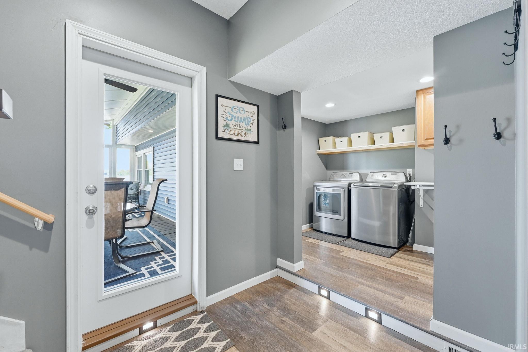Laundry area featuring wood-finish flooring, recessed lighting, and wall-mounted shelving